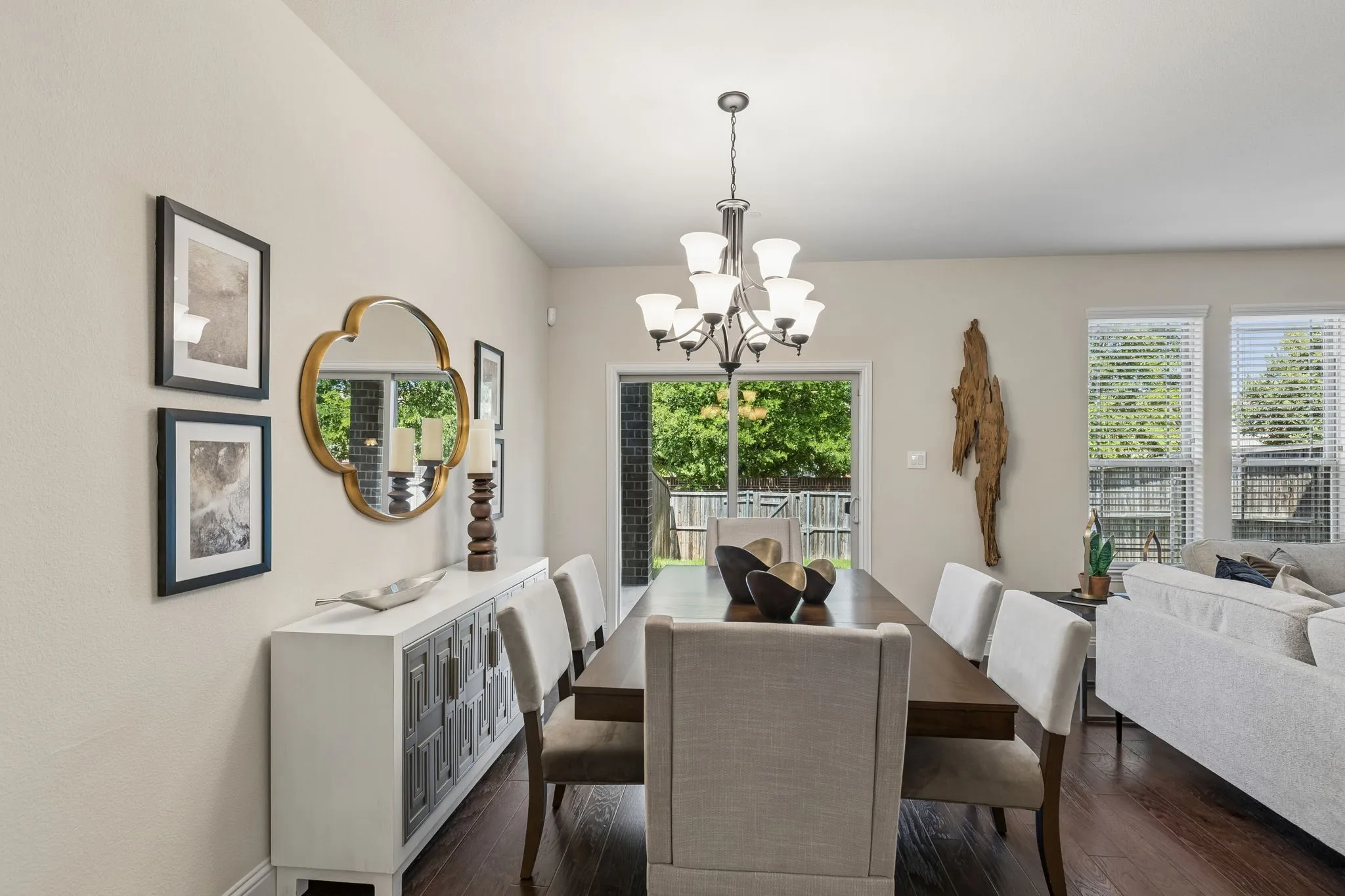Dining area with a multi-light chandelier, wood-finish flooring, and a sliding glass door