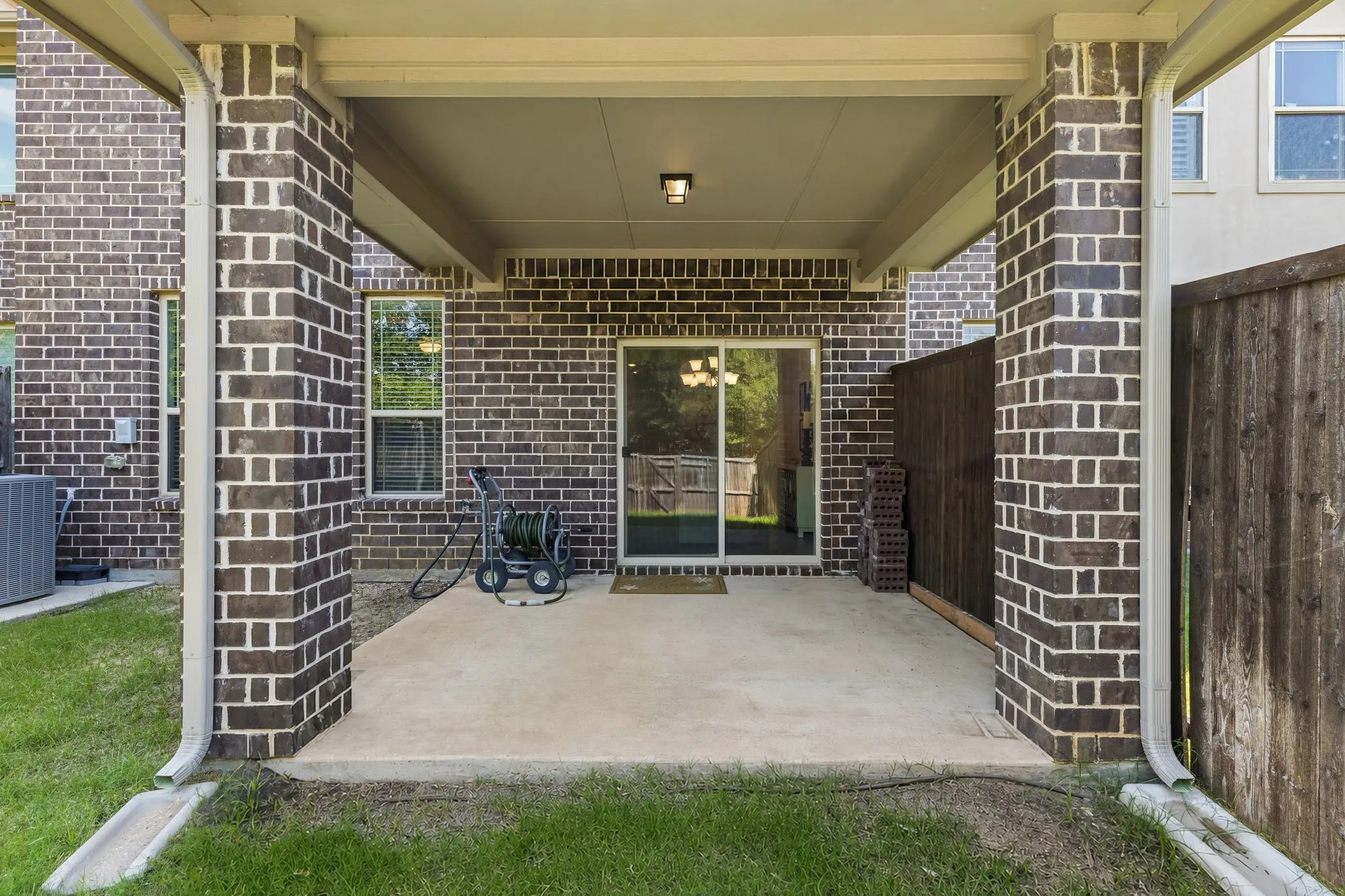 Covered patio featuring a concrete slab and brick columns