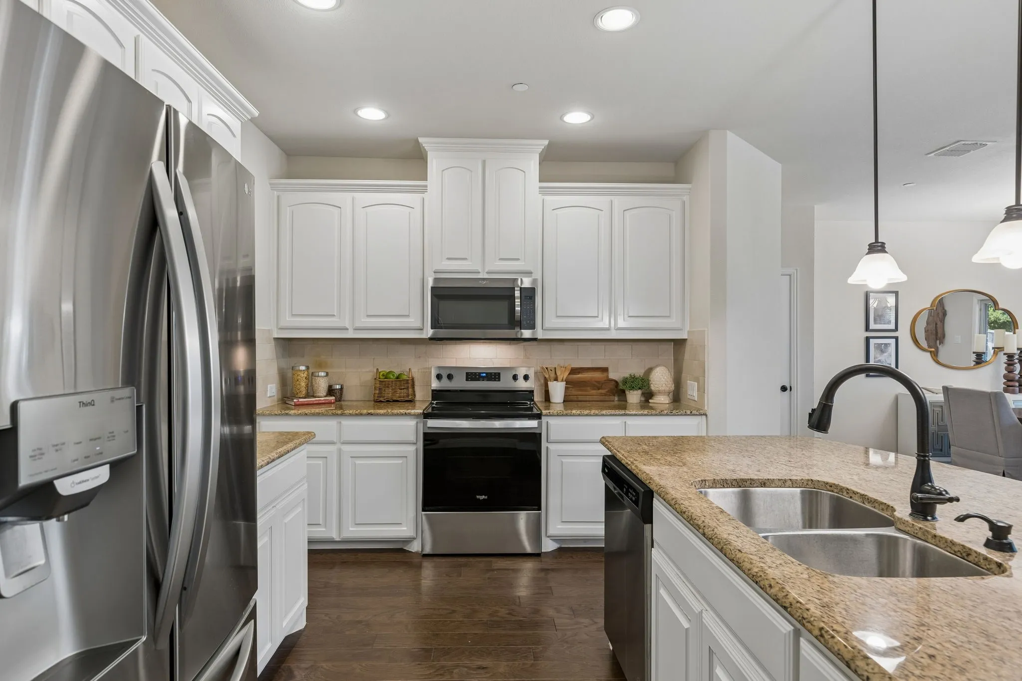 Kitchen featuring white cabinetry, granite countertops, stainless steel appliances, dark wood-finish flooring, and recessed lighting