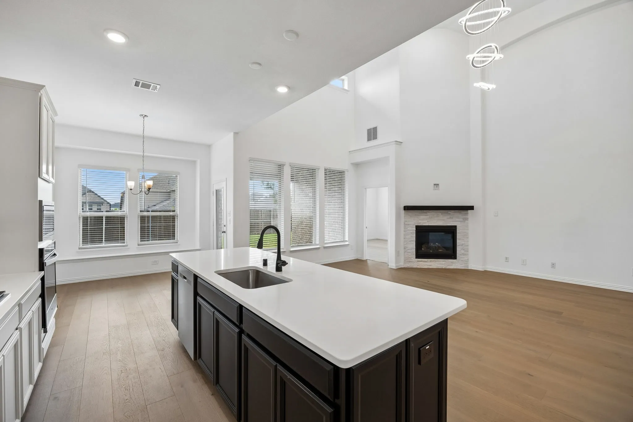 Contemporary kitchen island with an integrated sink and matte black faucet, featuring a light countertop and dark cabinetry