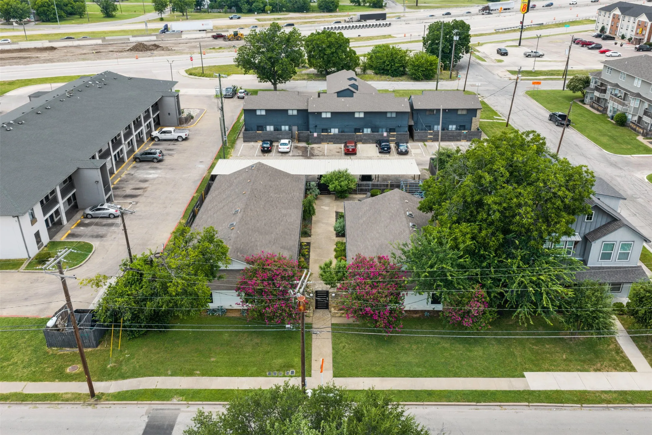 Aerial perspective showcasing multiple residential structures with gabled roofs and surrounding green spaces