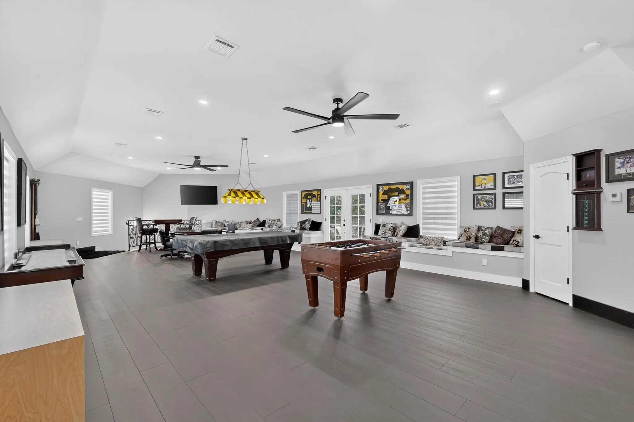 Spacious bonus room featuring vaulted ceilings, recessed lighting, wood-finish flooring, and multiple windows with horizontal blinds