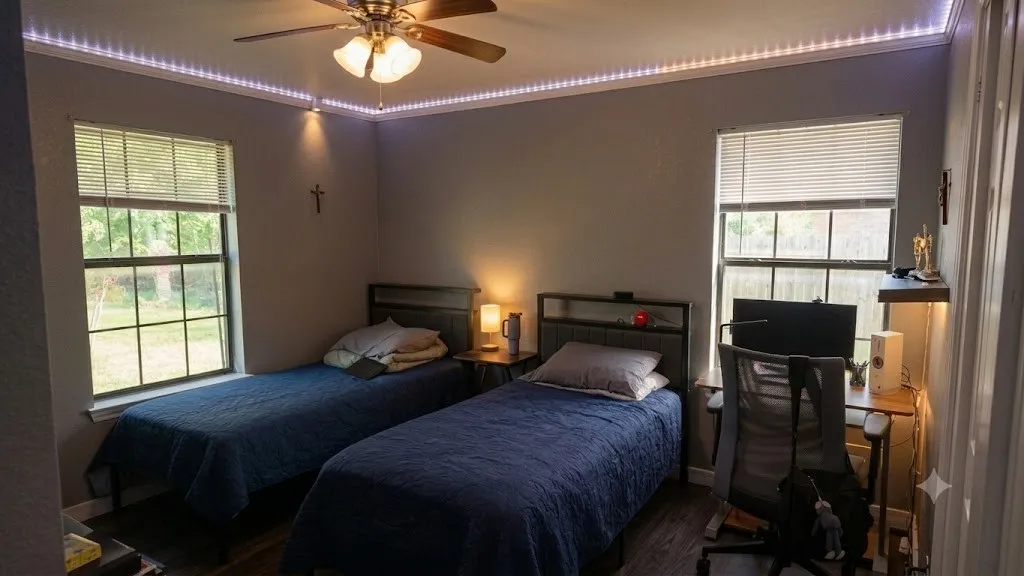 Room featuring wood-finish flooring, two window openings with blinds, a ceiling fan with integrated lighting, and crown molding with accent lighting