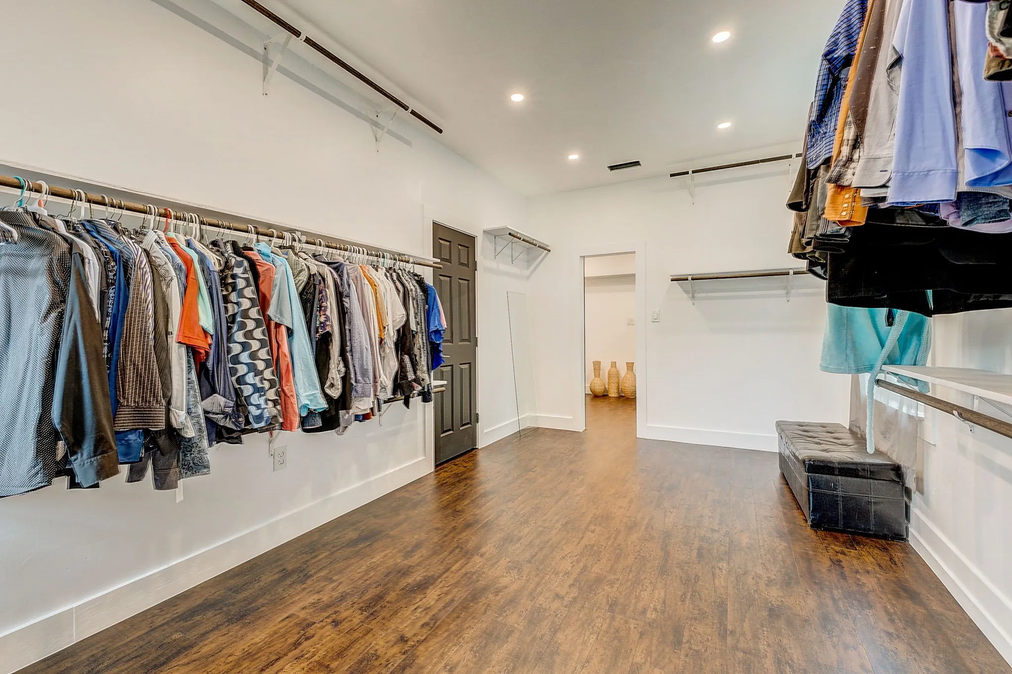 Oversized Primary Walk-in closet with hardwood floors