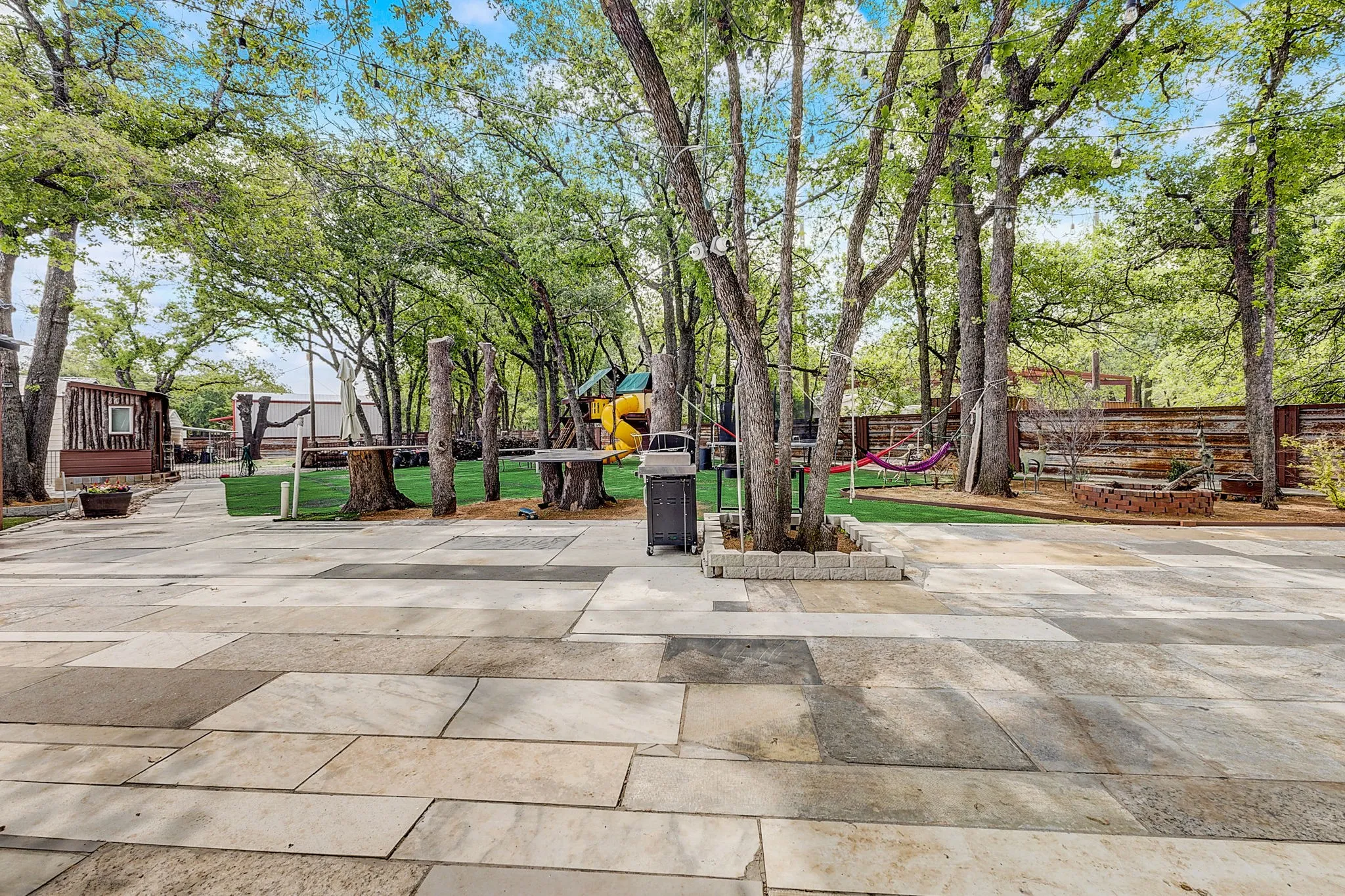 View of yard featuring a playground, BBQ, Hammocks large outdoor entertainment area.