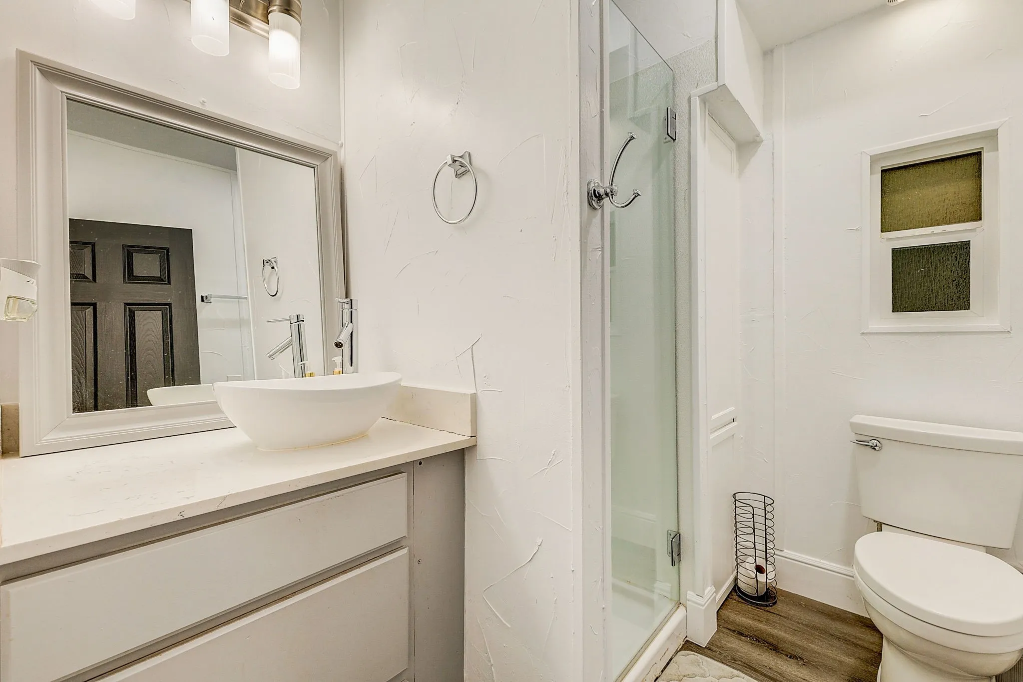 Bathroom with wood-type flooring, vanity, toilet, and walk in shower