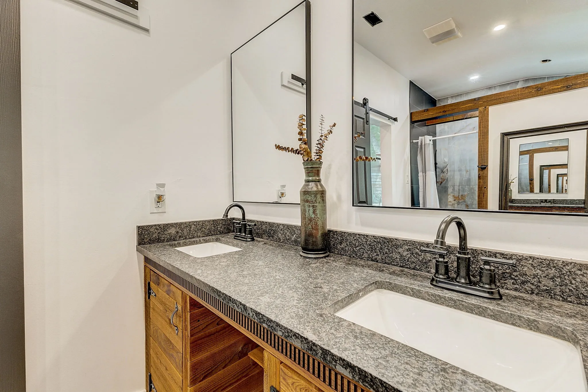 Primary Bathroom with his and her showers, hardwood flooring, a tile shower, and a large double vanity