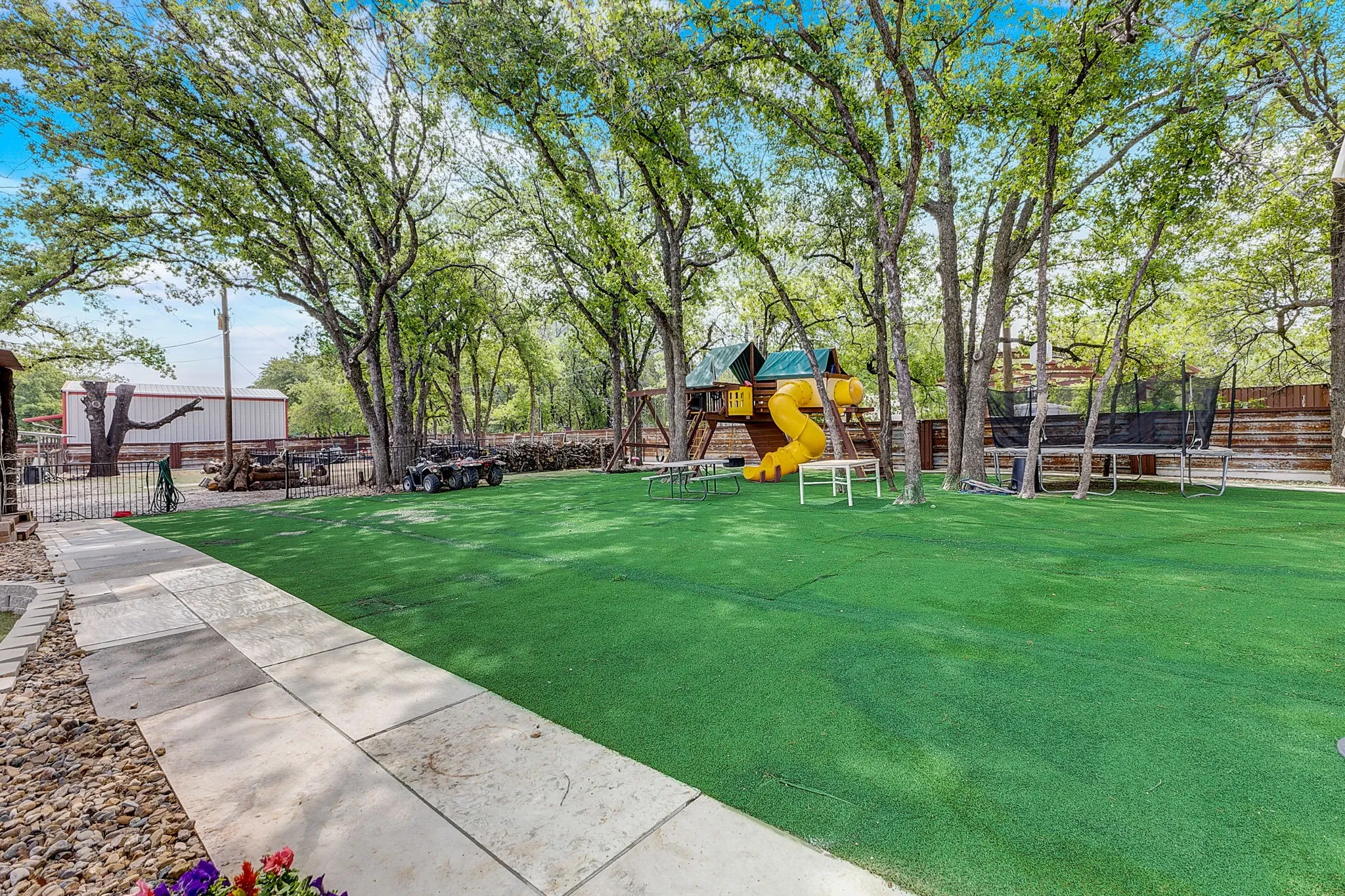 View of yard with a trampoline and a playground