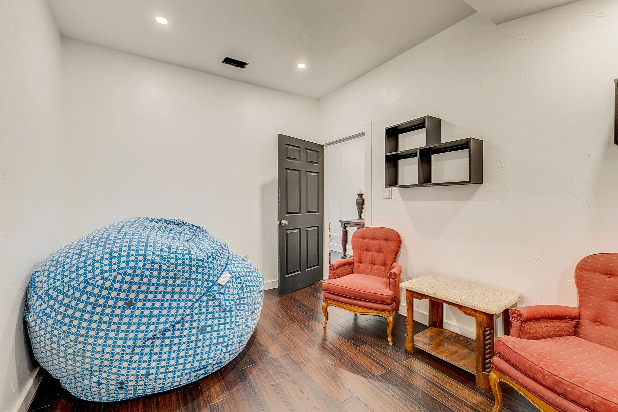 Spare room with luxury vinyl flooring, crown molding, ceiling fan, and built in shelves, can be used as a bedroom, home office, or workout room.