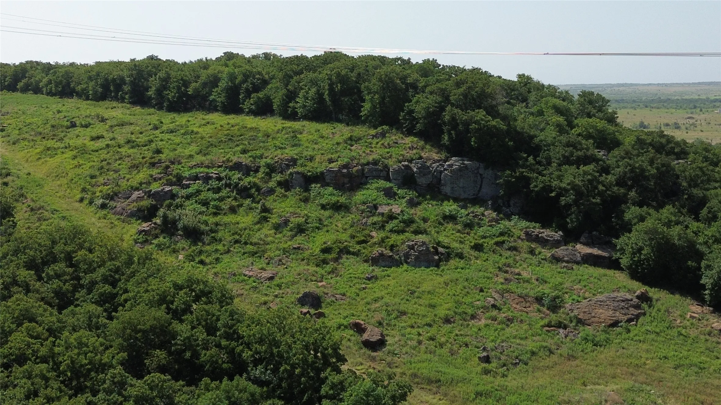 Expansive acreage featuring natural rock outcroppings, mature tree lines, and varied topography