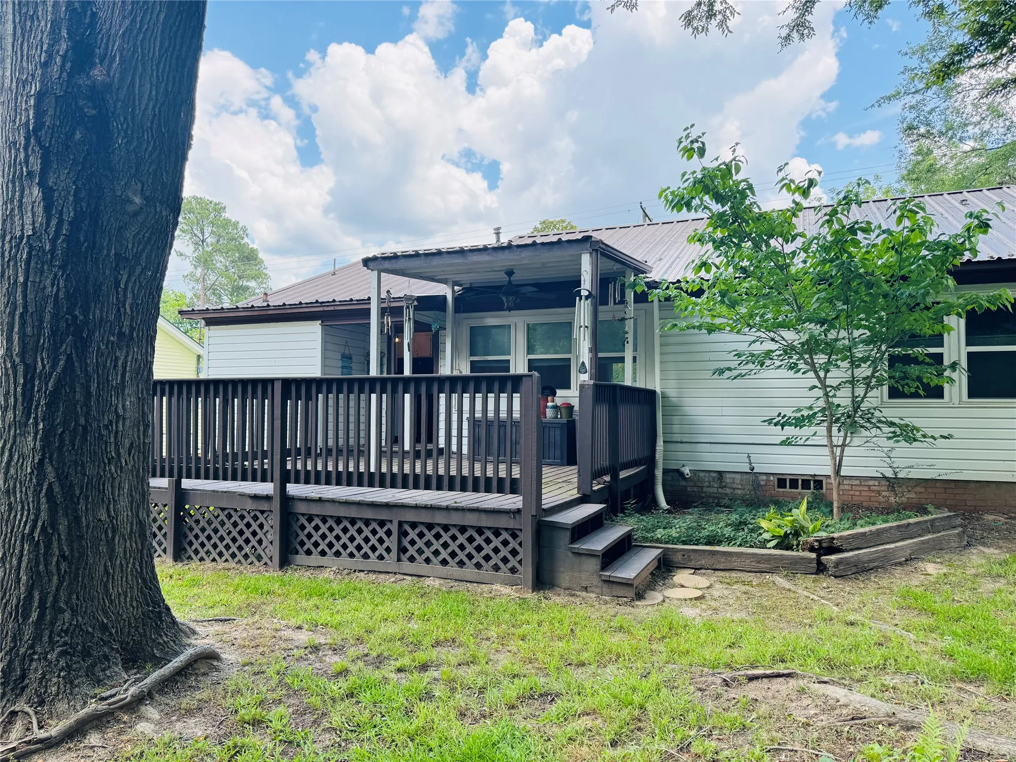 Back of property featuring partially covered and partially open deck