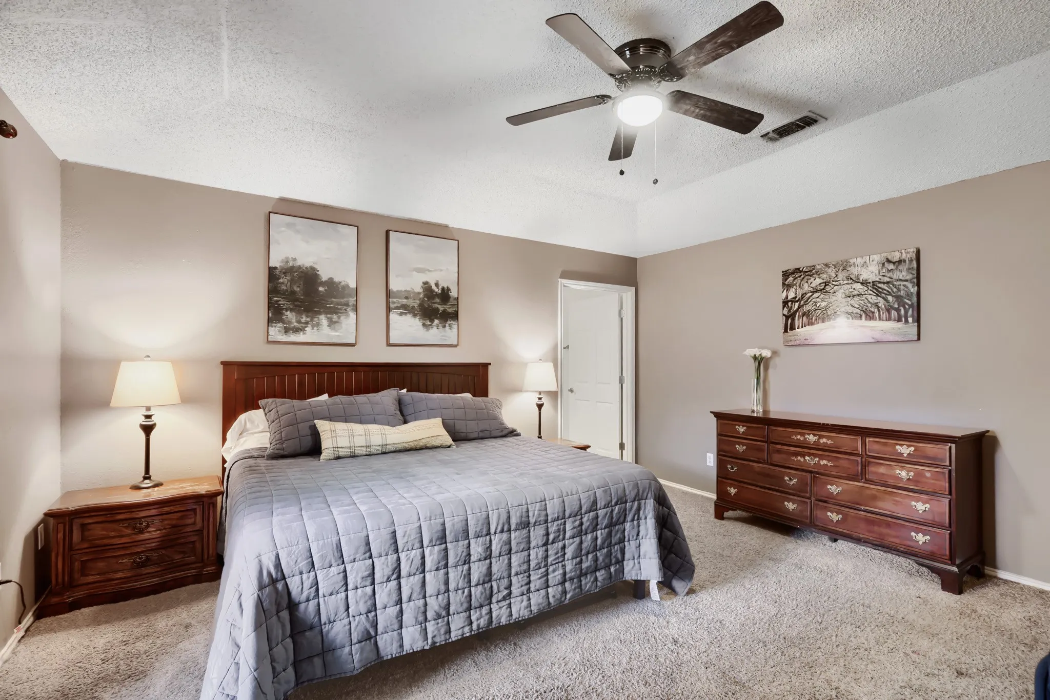 Spacious room featuring a tray ceiling, ceiling fan with integrated lighting, and neutral wall tones