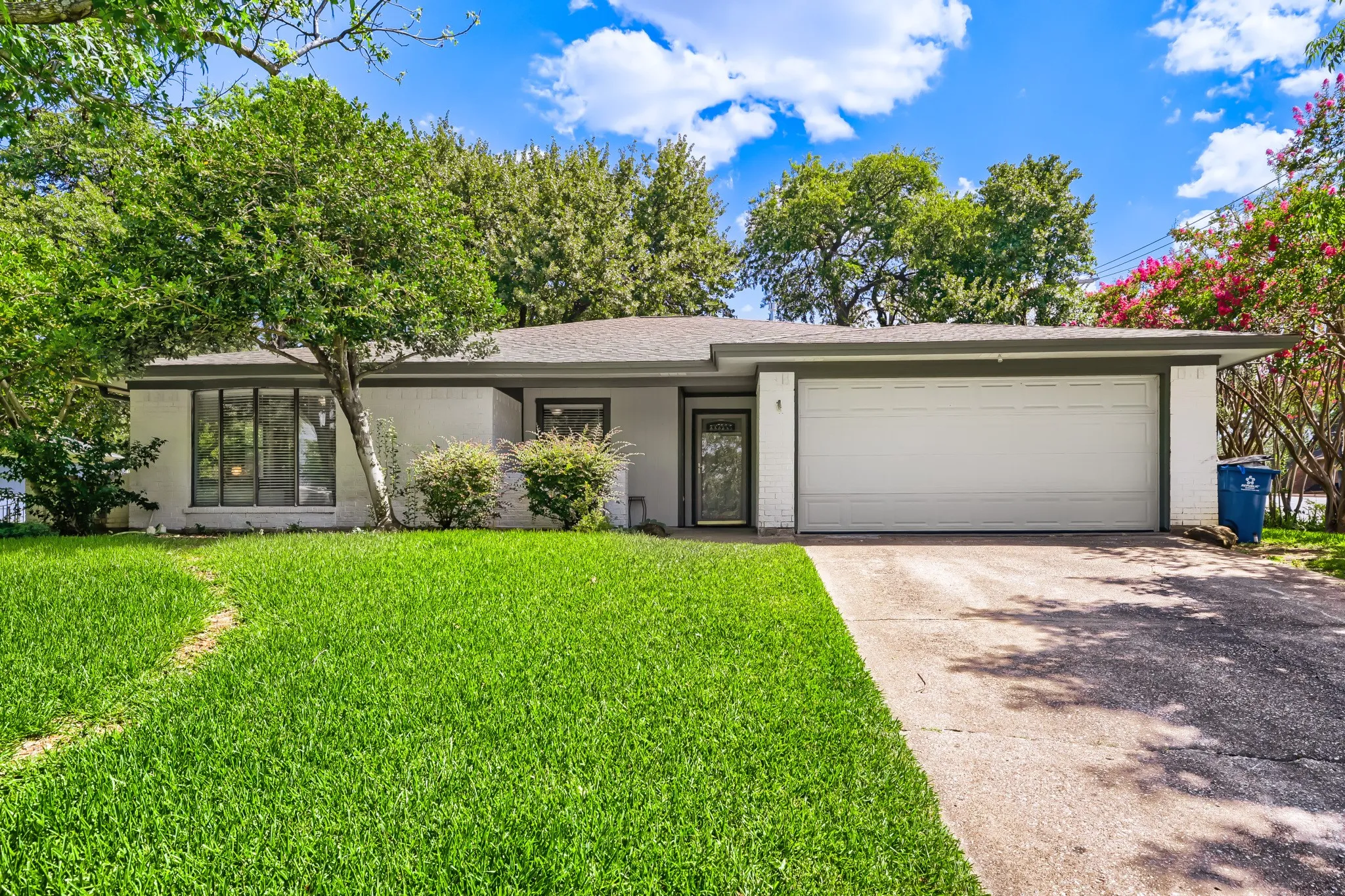 Single-story residence featuring a white brick exterior and a dark trim
