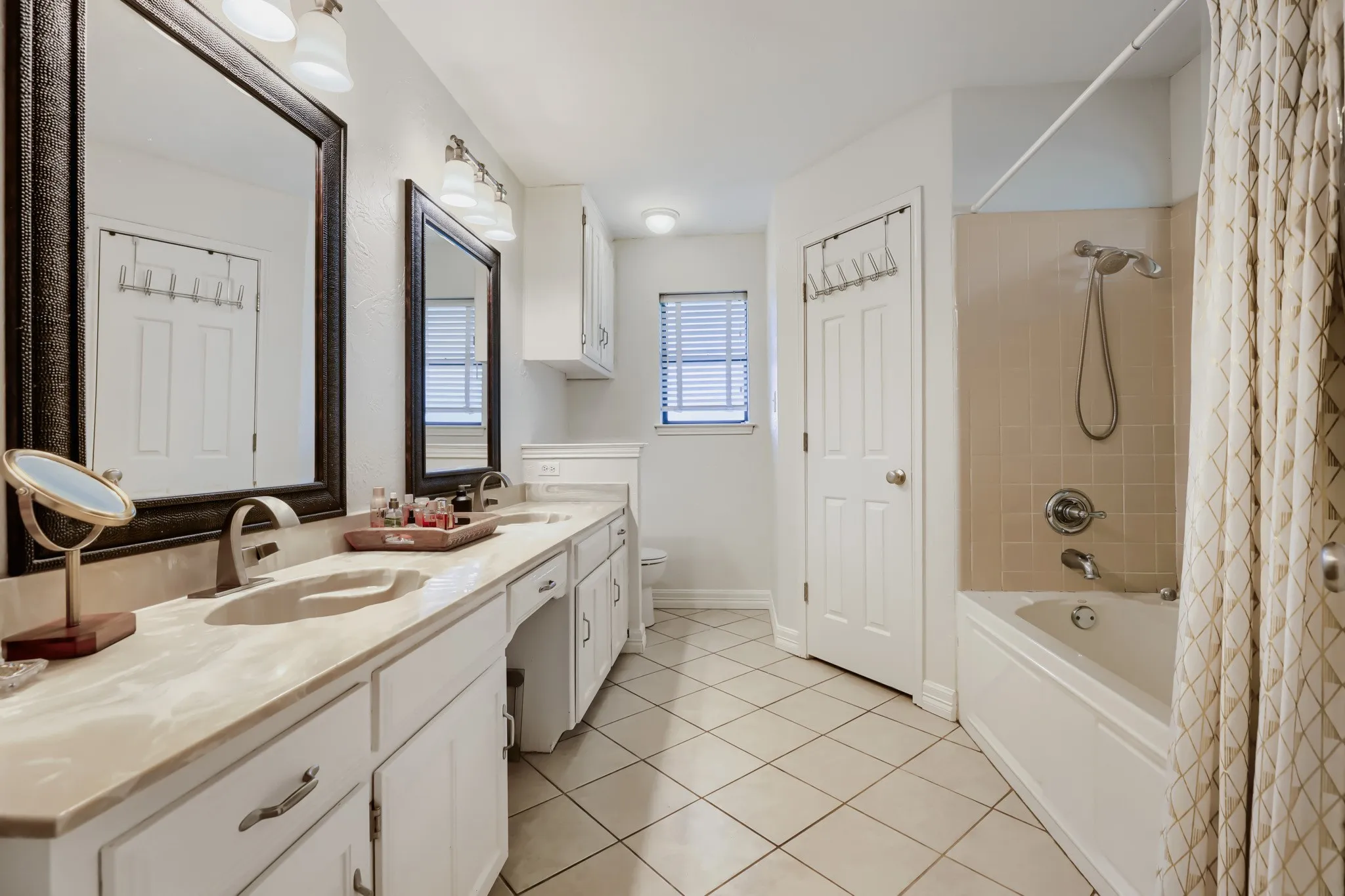 Double vanity with integrated sinks, light-toned countertop, and undermount cabinetry