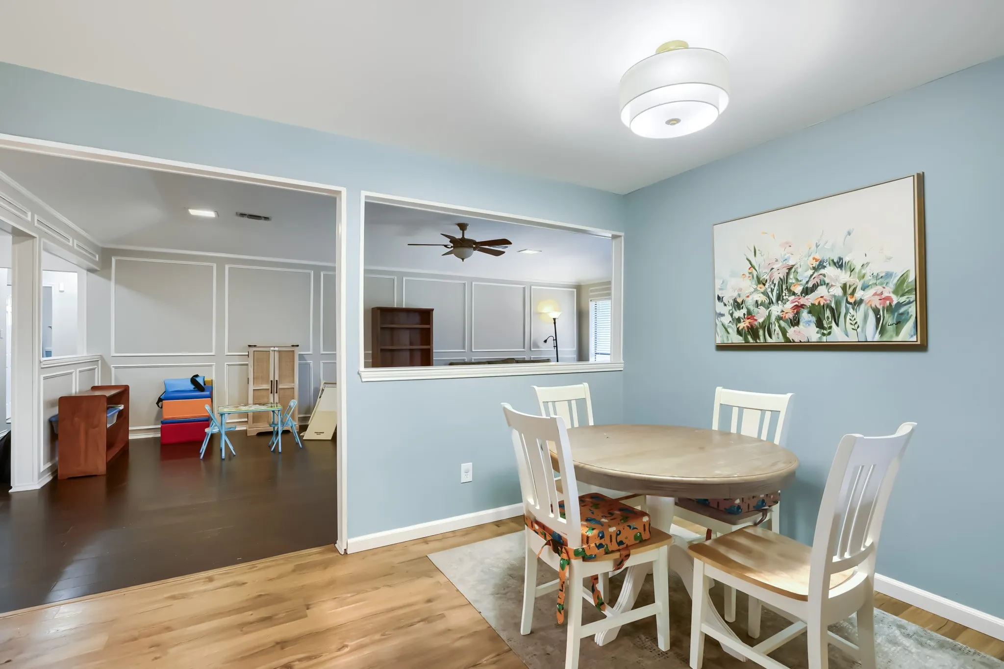 Bright dining area featuring wood-finish flooring and a contemporary semi-flush mount ceiling light