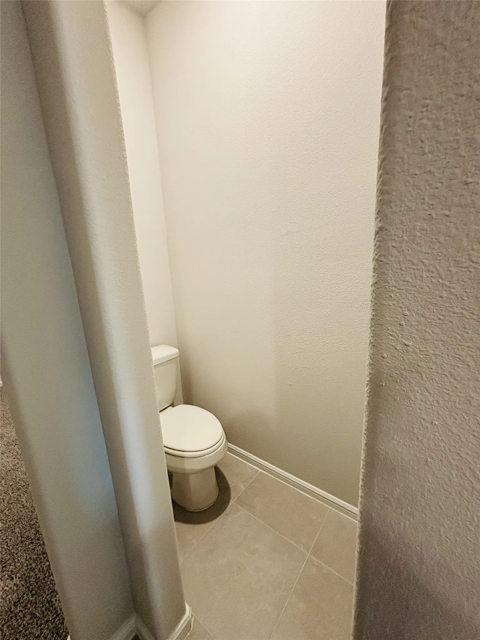 Bathroom with toilet and tile patterned flooring