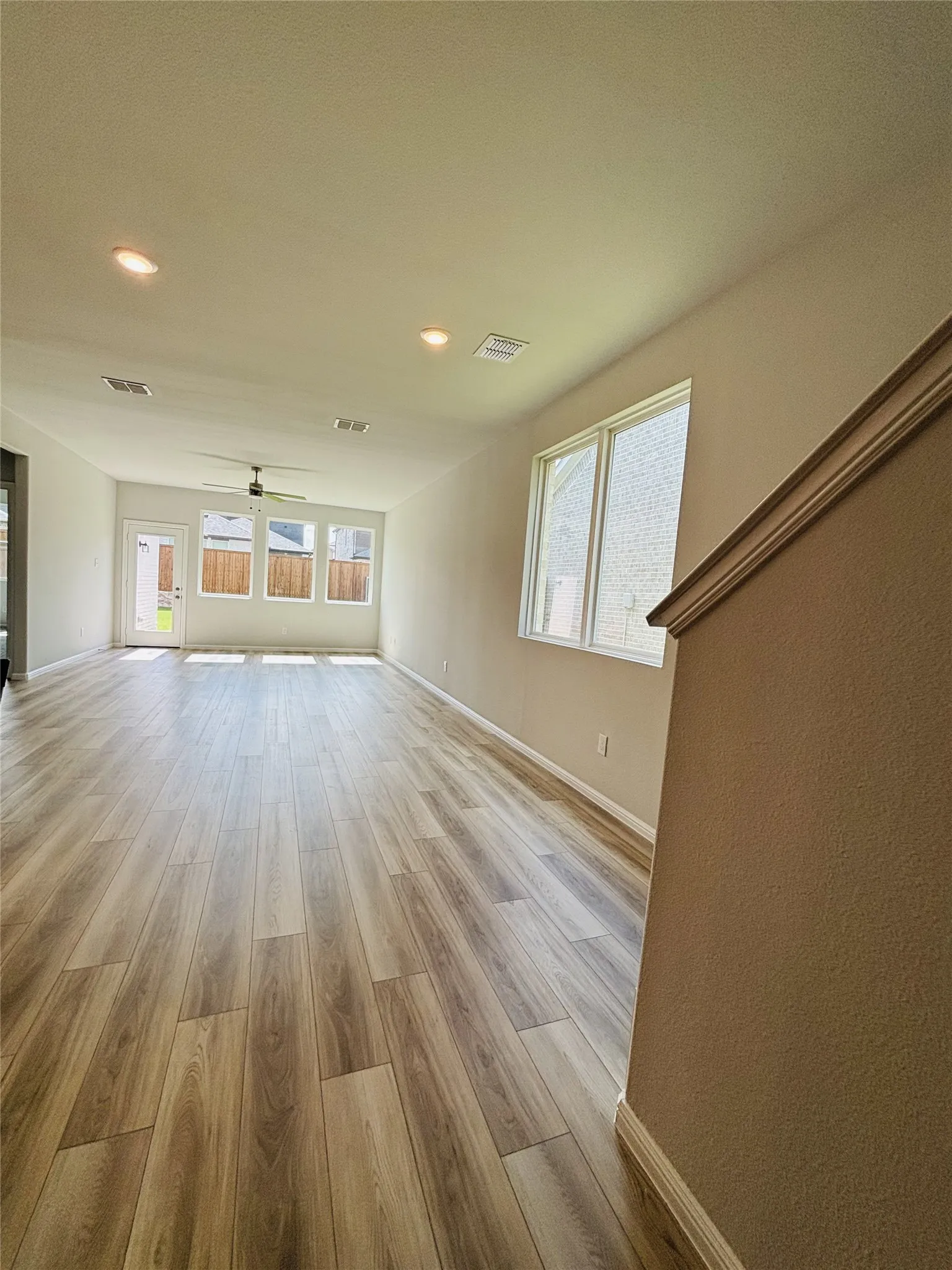 Unfurnished living room with a ceiling fan, light wood-style flooring, healthy amount of natural light, and recessed lighting