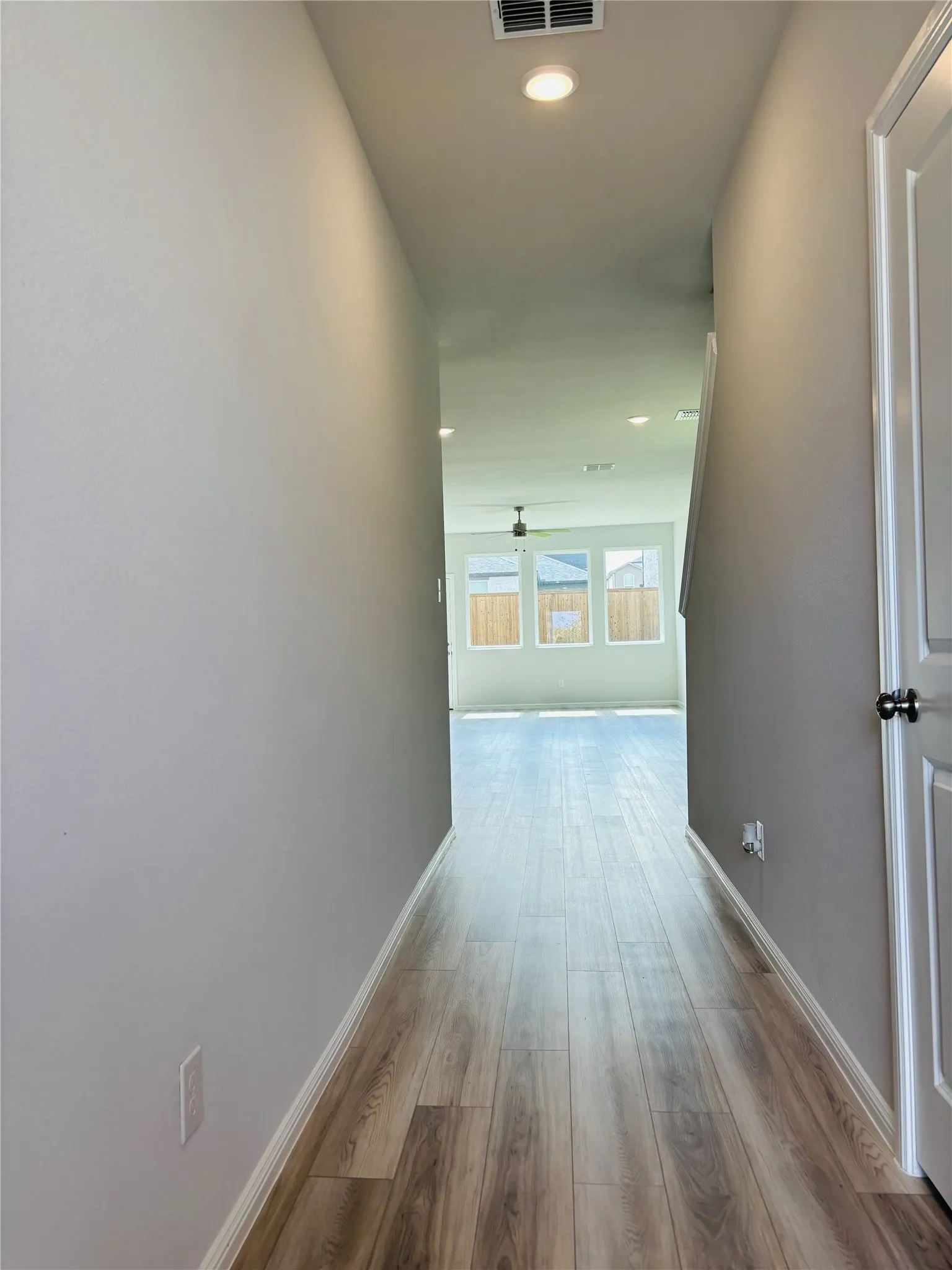 Hall with wood finished floors and recessed lighting