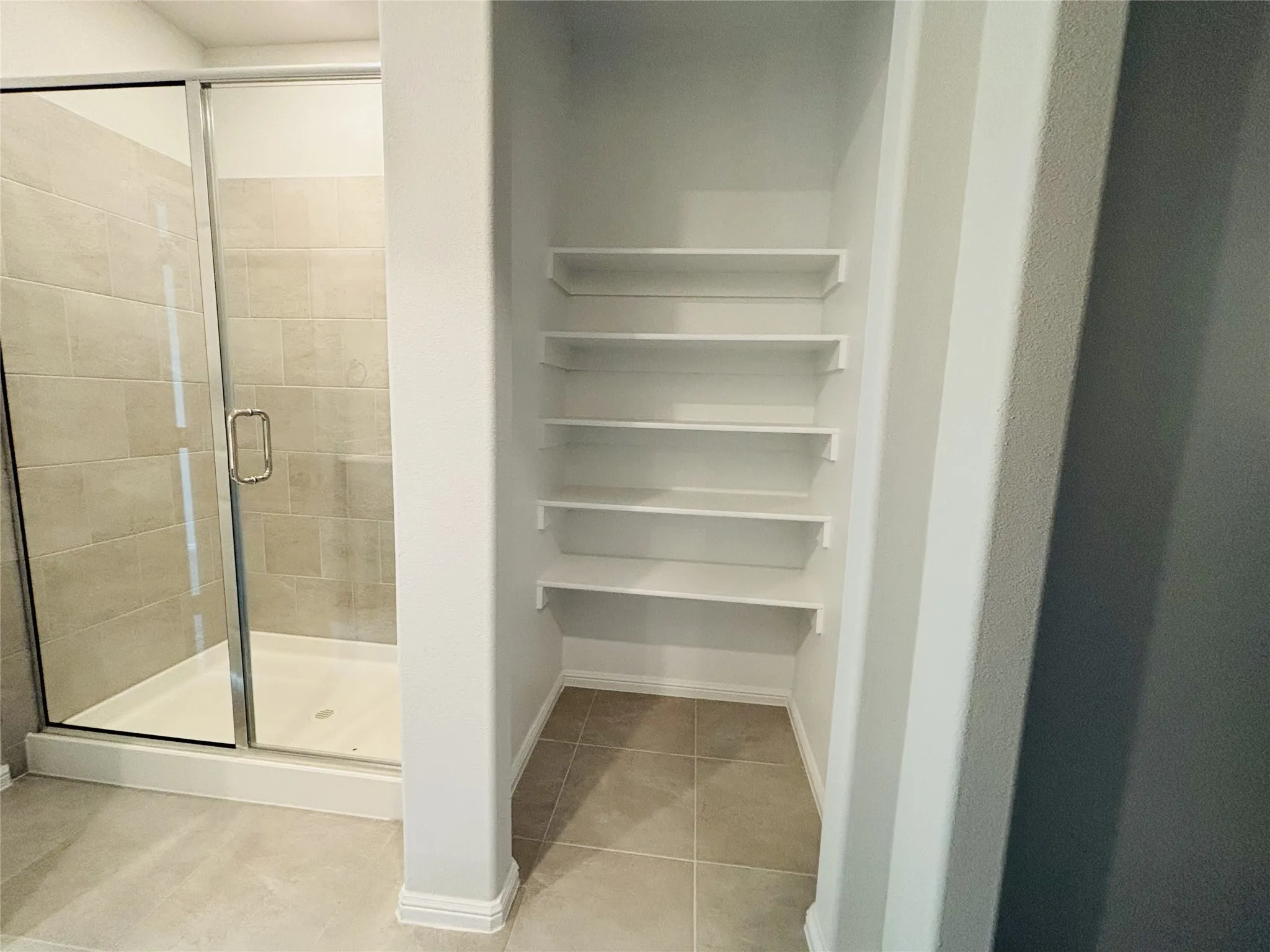 Bathroom with tile patterned flooring and a shower stall
