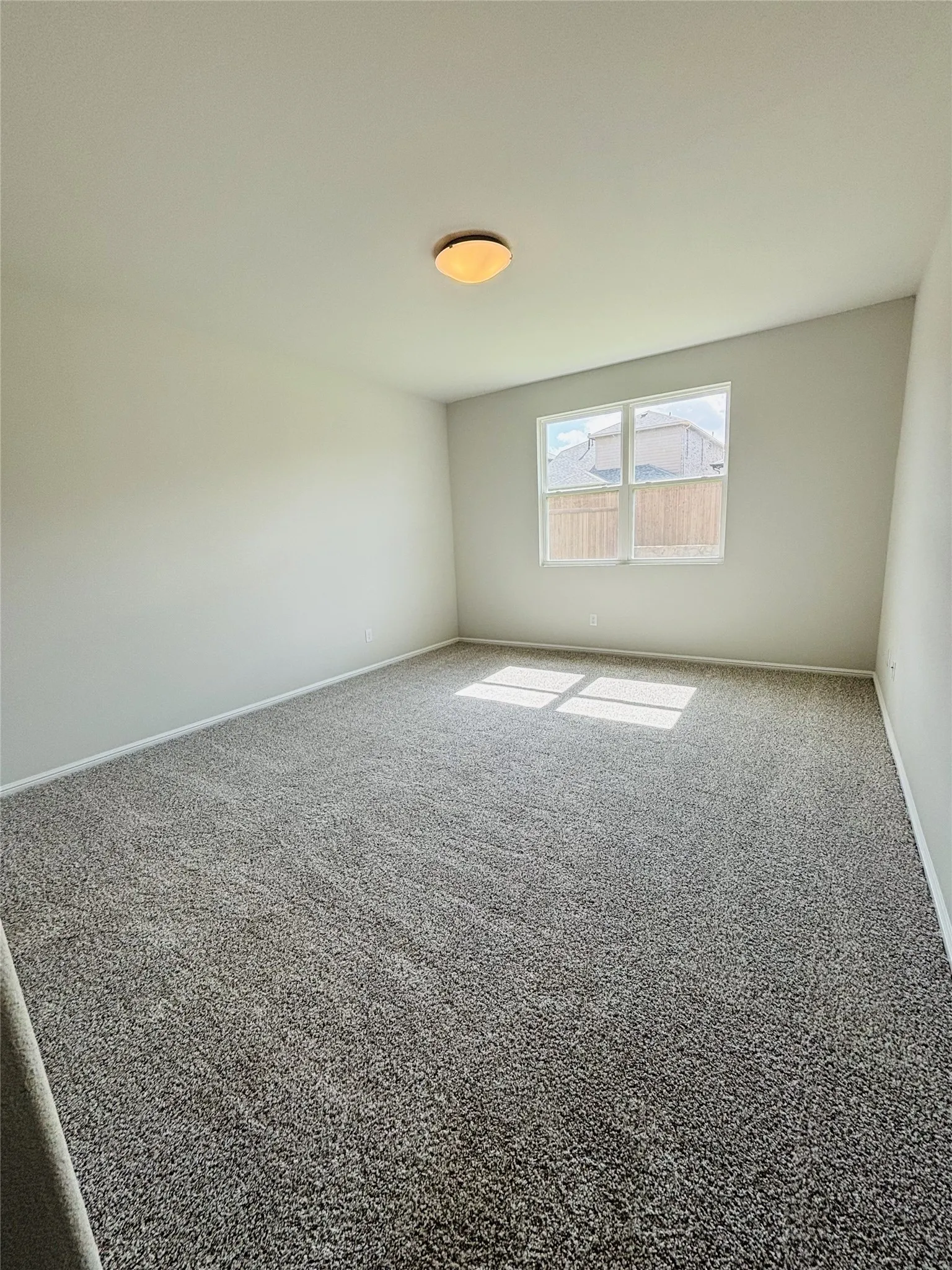 Spare room with carpet and baseboards