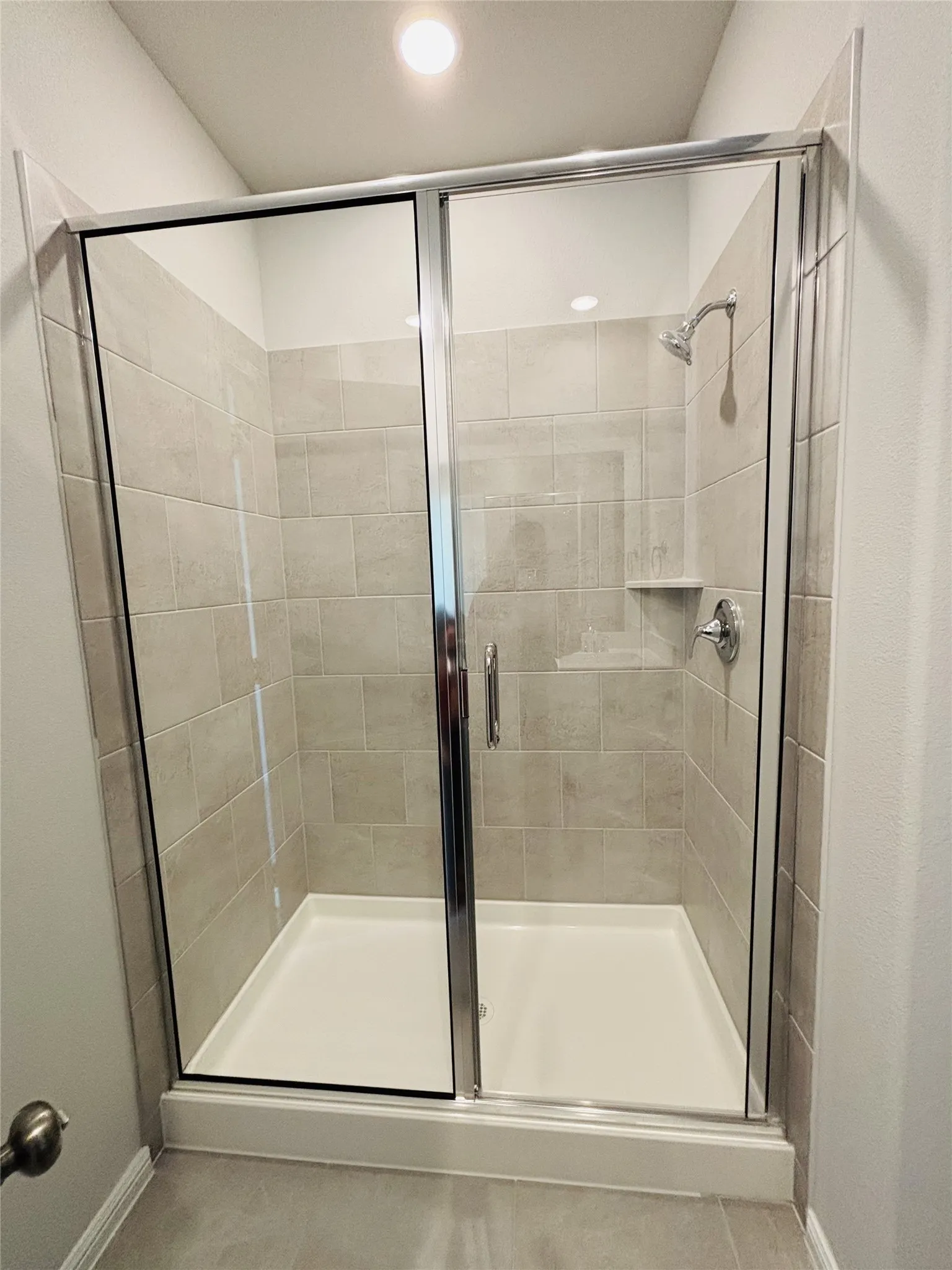Full bath featuring a stall shower, tile patterned flooring, and recessed lighting