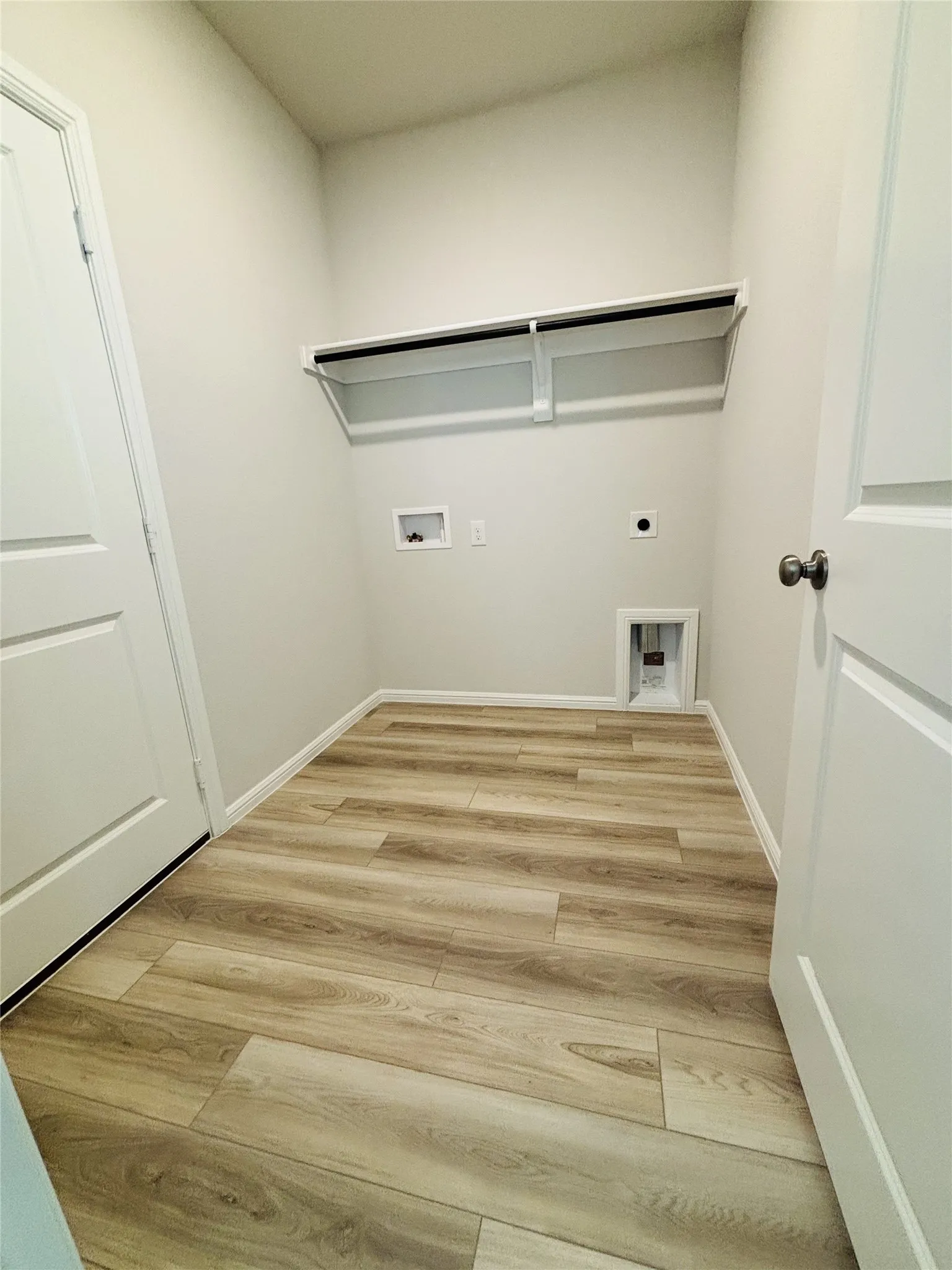 Laundry room featuring electric dryer hookup, light wood-style floors, and hookup for a washing machine