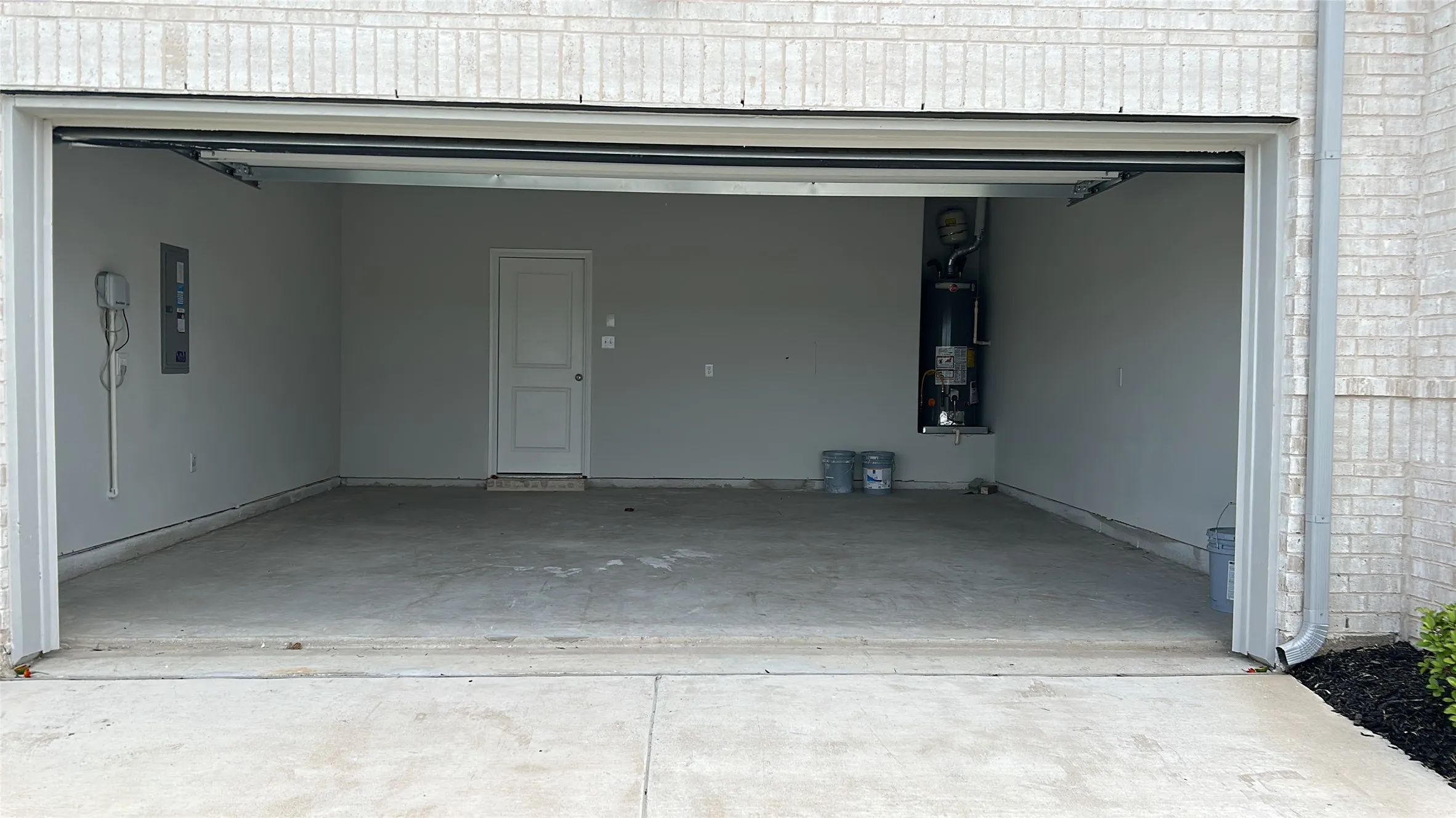 Garage featuring gas water heater and electric panel