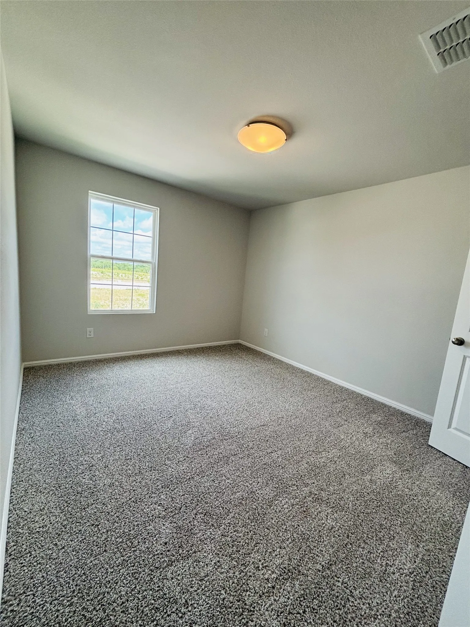 Carpeted empty room featuring baseboards