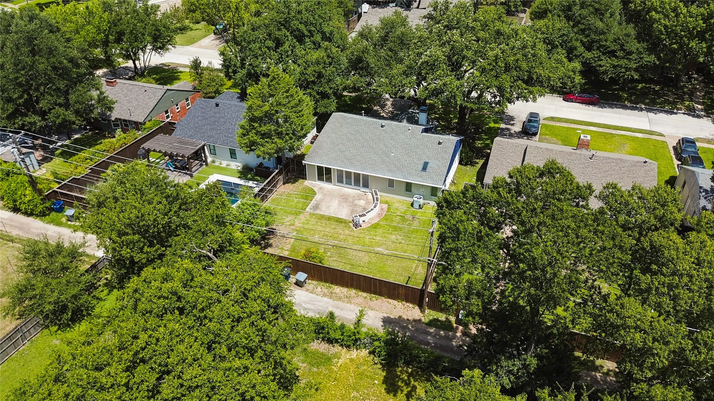 Expansive backyard featuring a manicured lawn, concrete patio, and privacy fencing