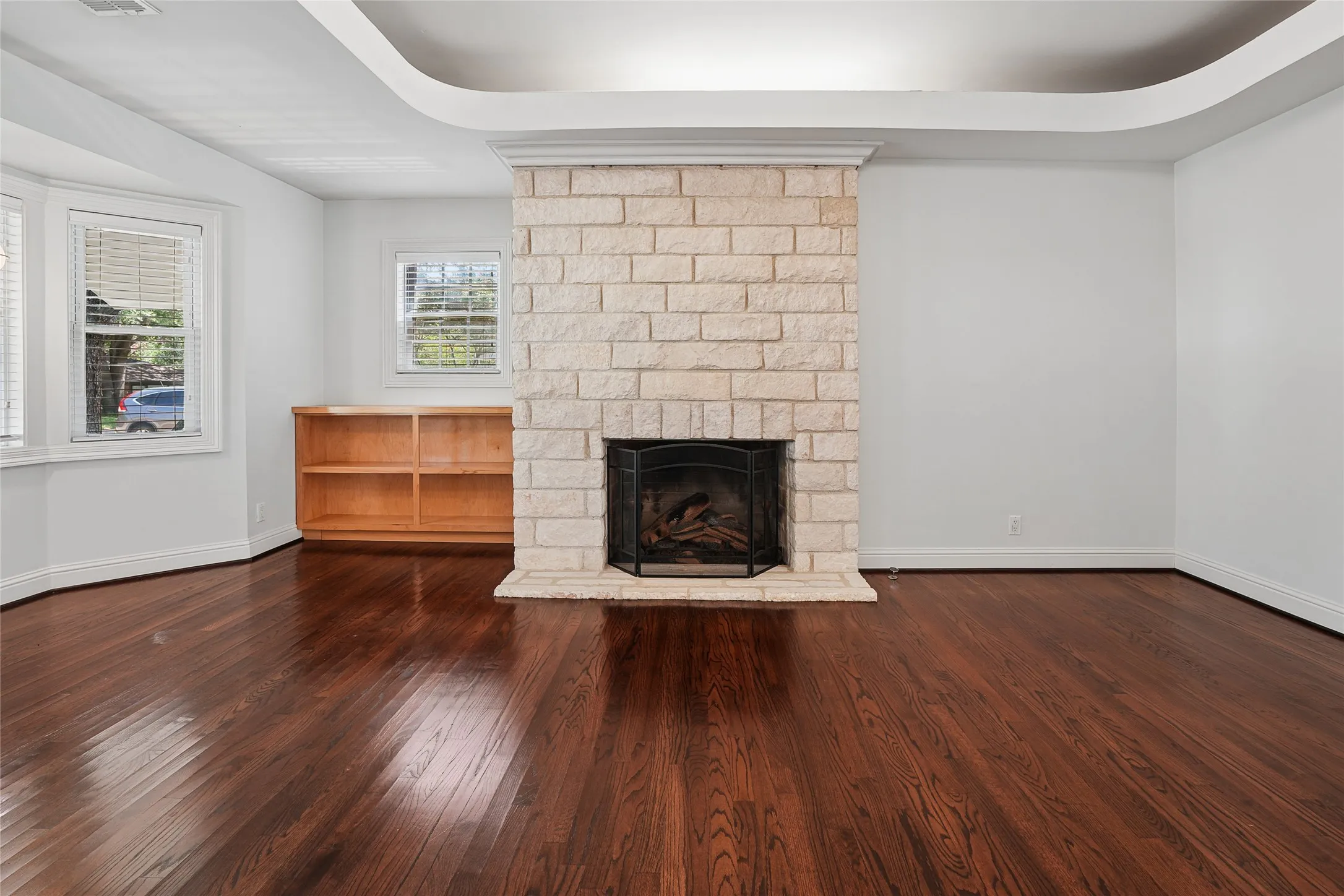 Central stone-clad fireplace featuring a dark firebox
