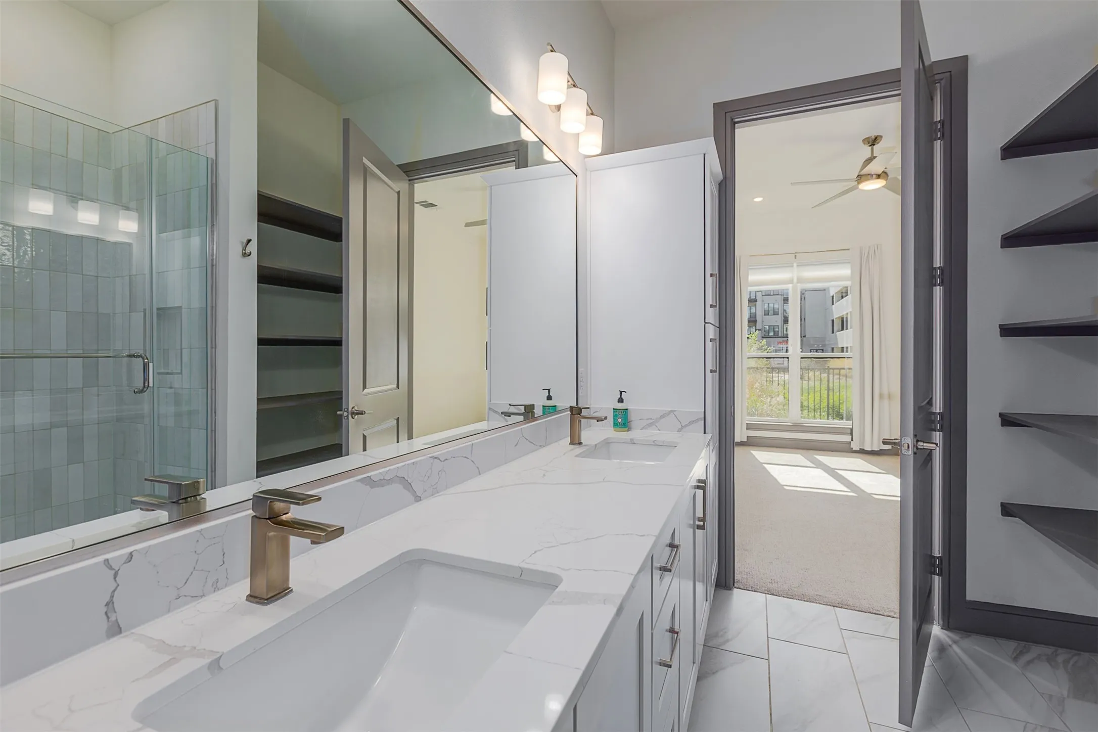 Bathroom vanity featuring dual under-mount sinks, a quartz-finish countertop, and brushed bronze-finish faucets