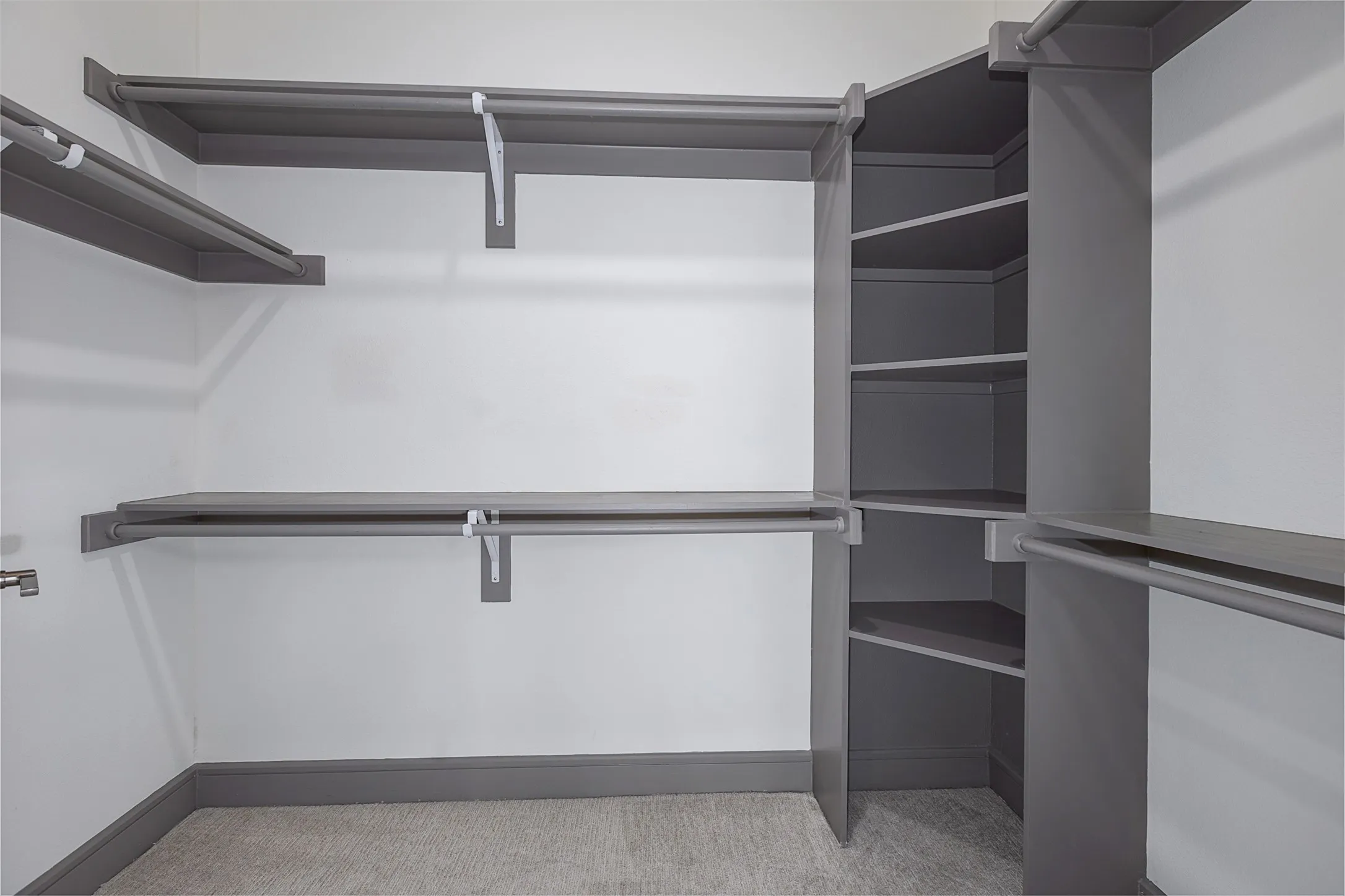 Organized closet system featuring multiple hanging rods and integrated shelving