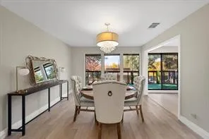Spacious dining area featuring wood-finish flooring, neutral wall tones, and recessed lighting