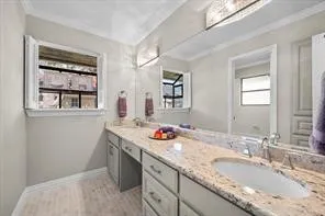 Double vanity with granite-style countertops, integrated sinks, and polished chrome fixtures