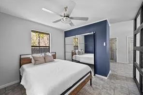 Bedroom featuring a ceiling fan, a window, and wood-finish flooring