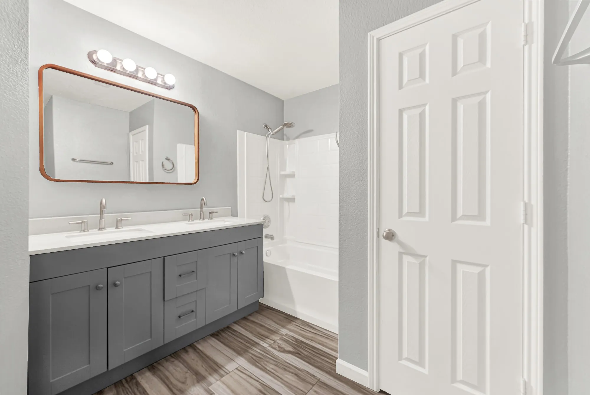 Bathroom featuring a dual vanity with gray cabinetry and white countertops