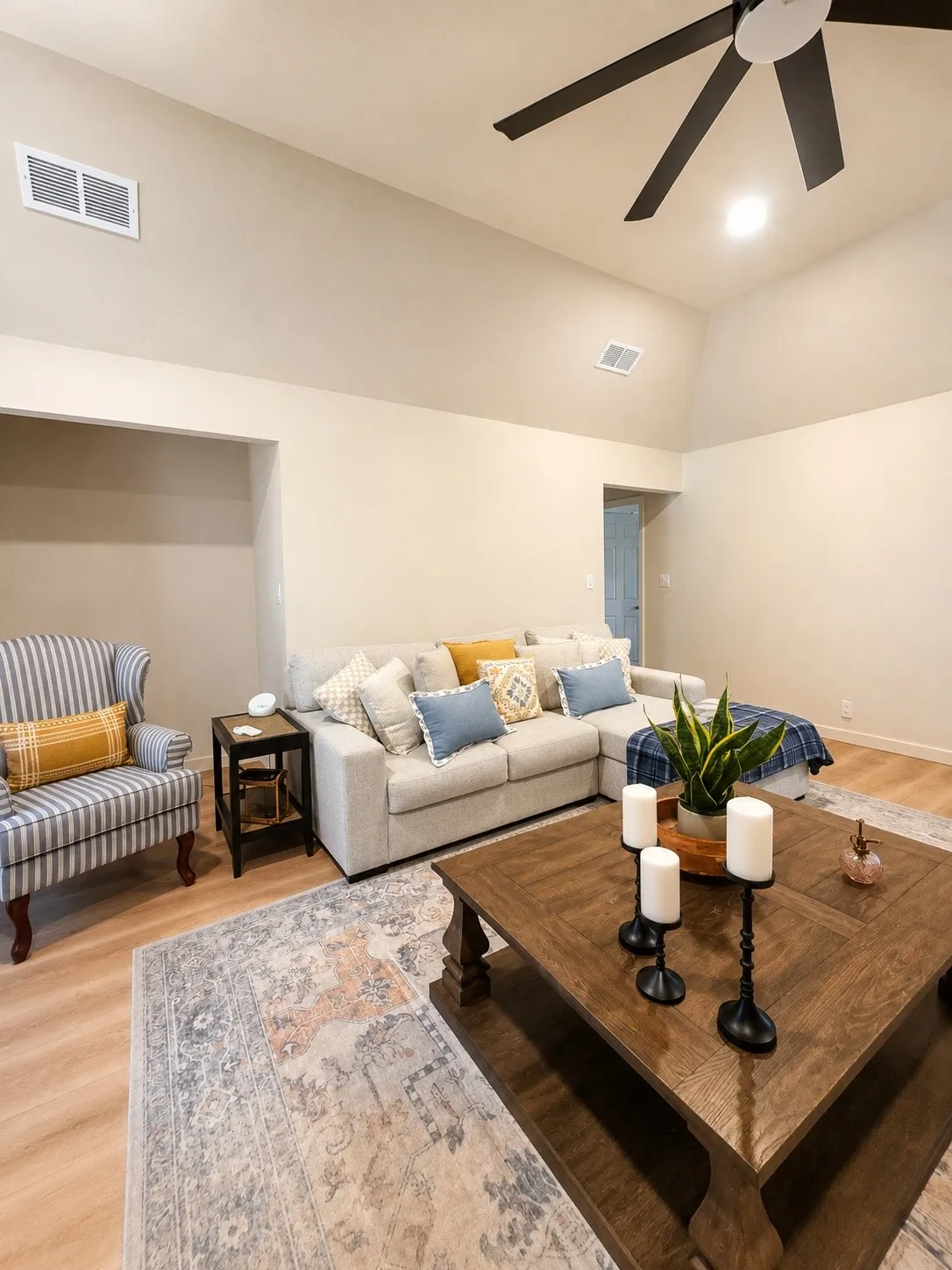 Living area featuring a vaulted ceiling with a ceiling fan, light wood-finish flooring, and recessed lighting