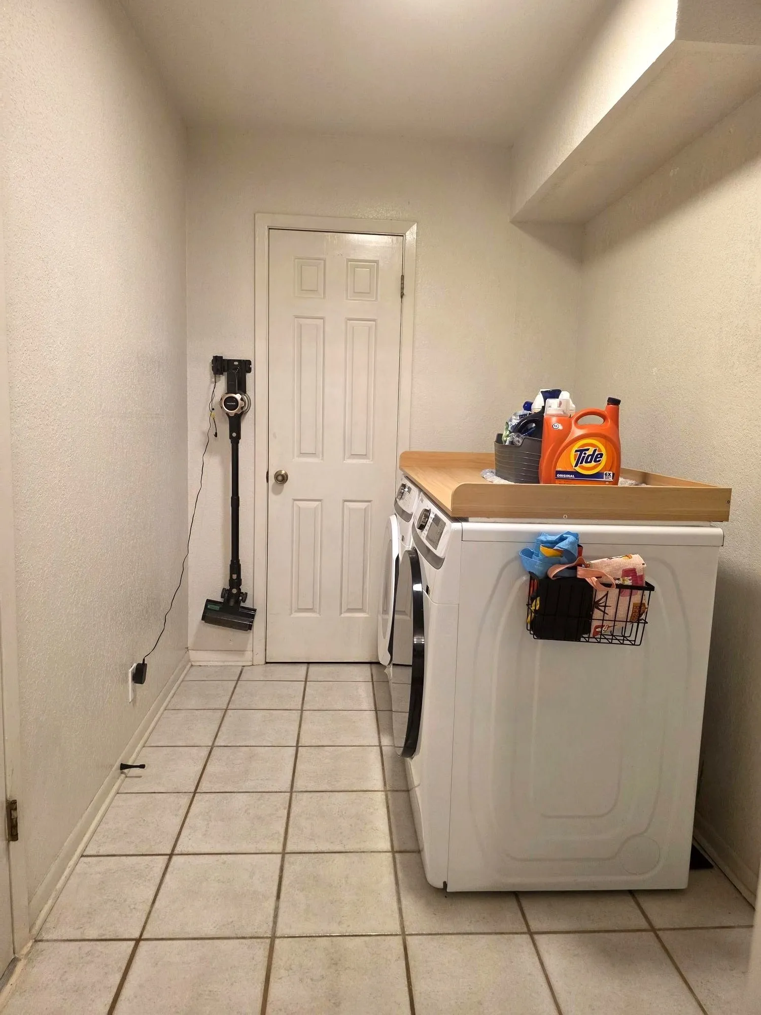 Utility area featuring tile flooring, a built-in countertop, and a white paneled door