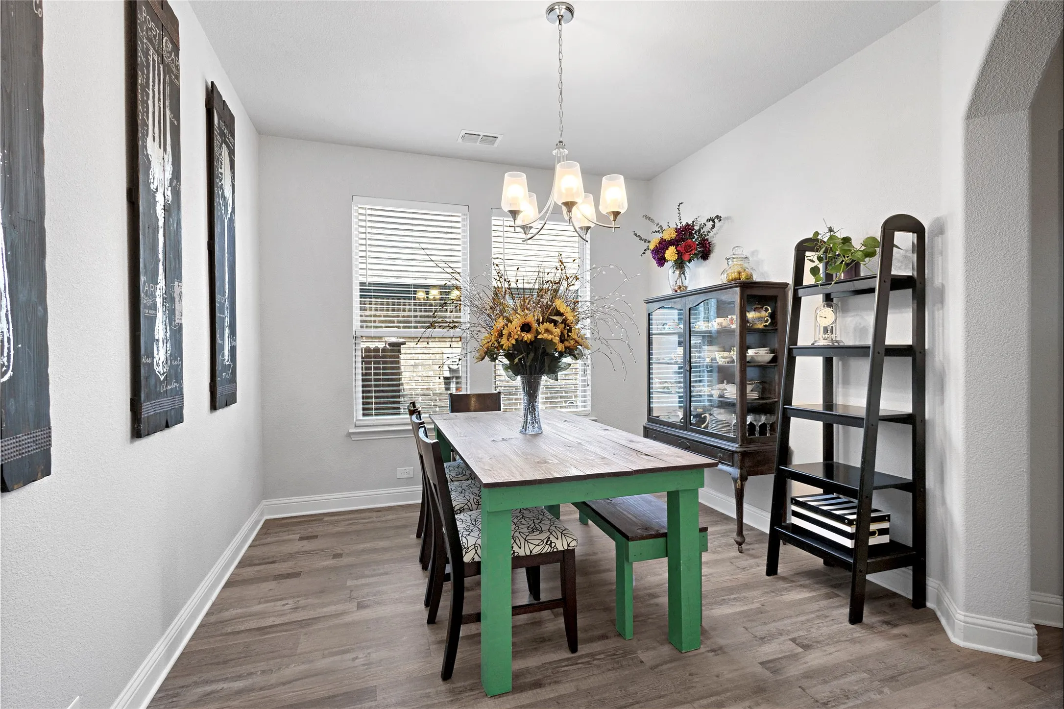 Well-lit interior space featuring wood-finish flooring, white baseboards, and neutral wall paint