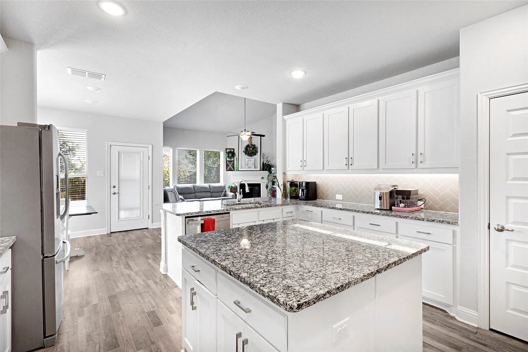 Modern kitchen with a central island featuring a granite countertop