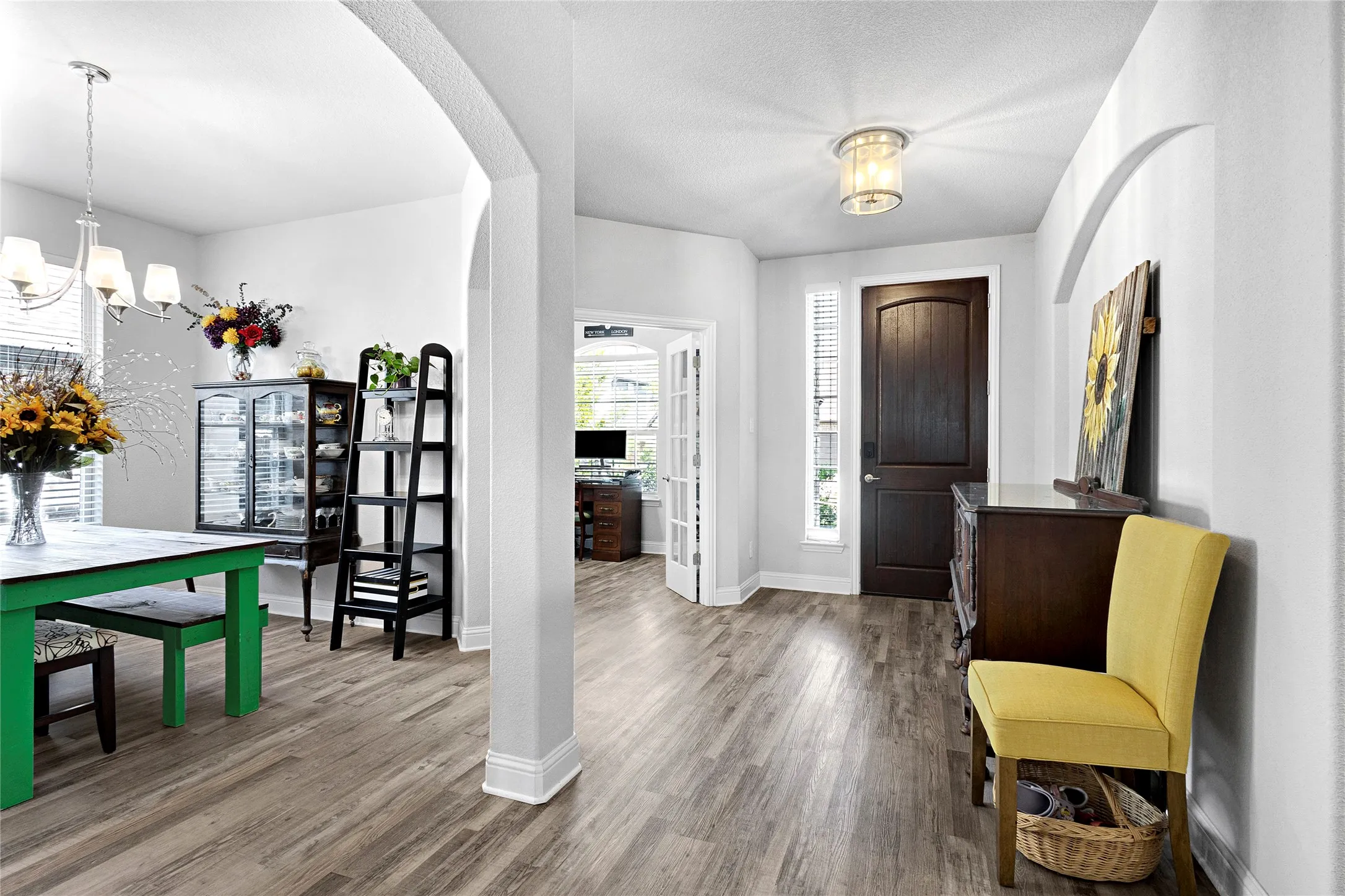 Spacious entryway featuring wood-finish flooring, a dark wood-paneled door, and a flush mount light fixture