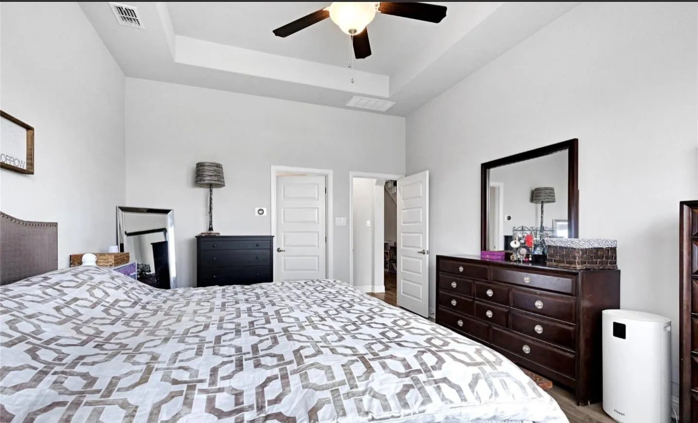 Expansive room featuring a tray ceiling, ceiling fan, and light-toned walls