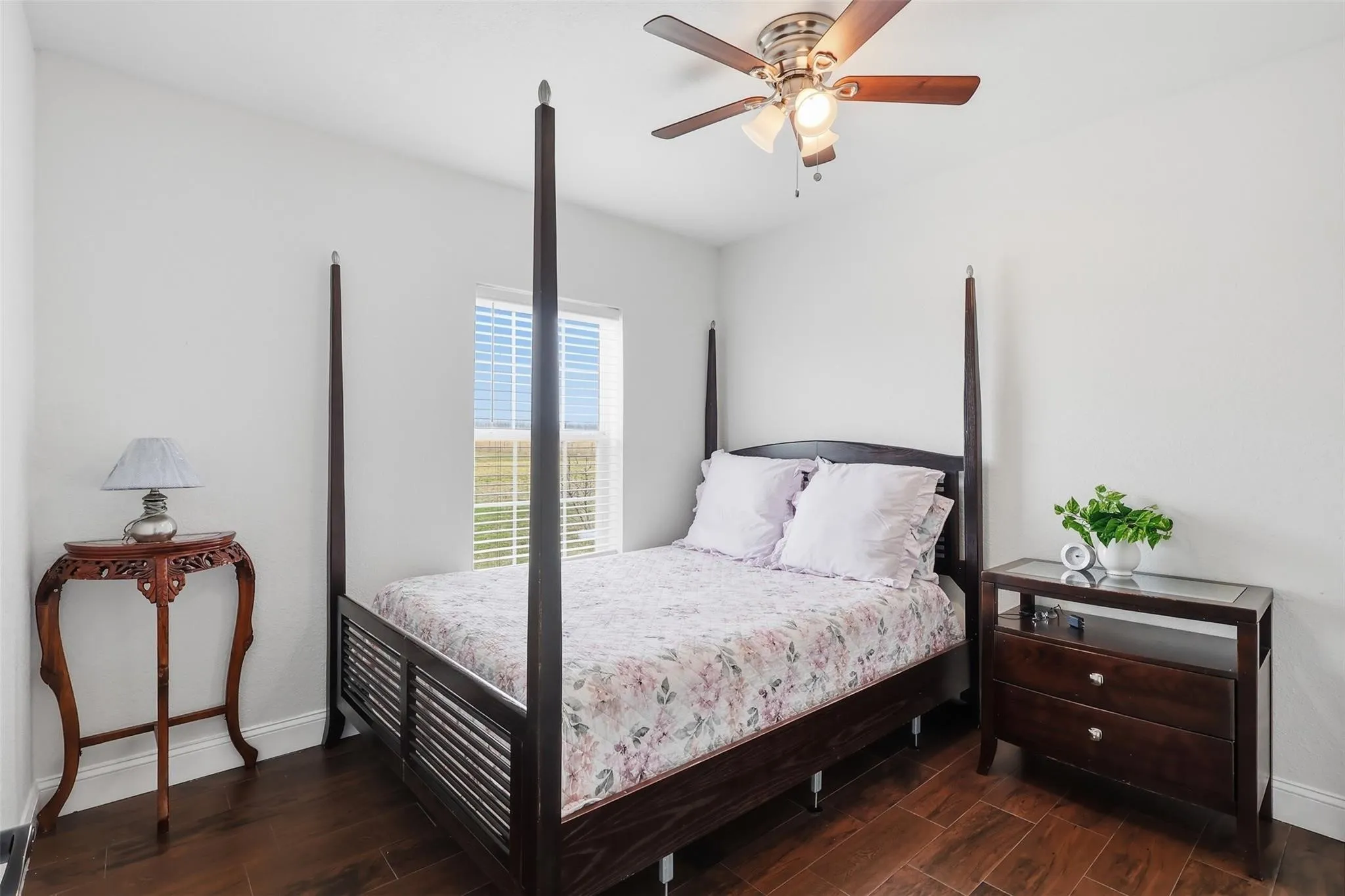 Interior room featuring wood-finish flooring, white walls, and a window with horizontal blinds
