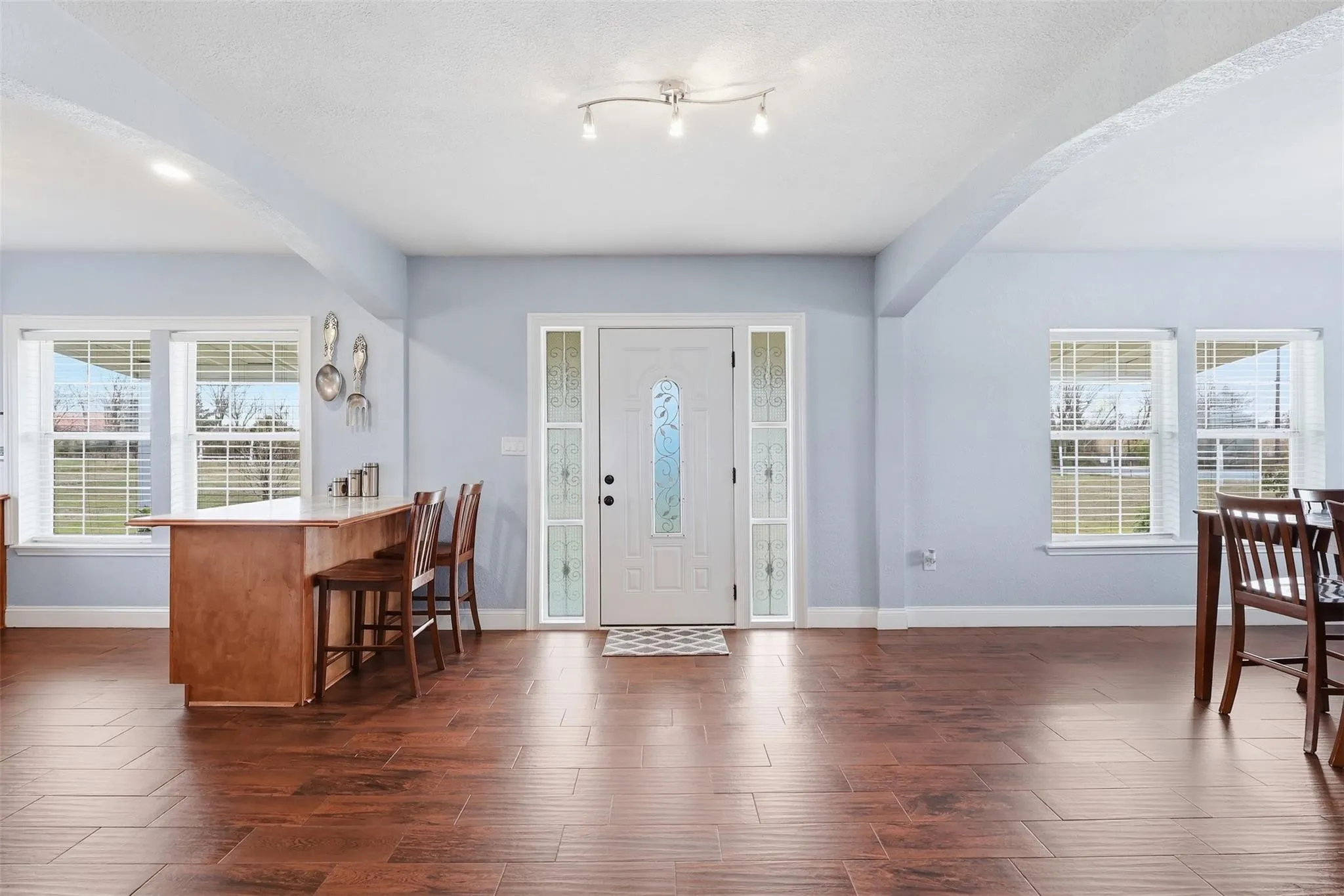 Entryway featuring a white paneled door with decorative glass inserts and coordinating sidelights