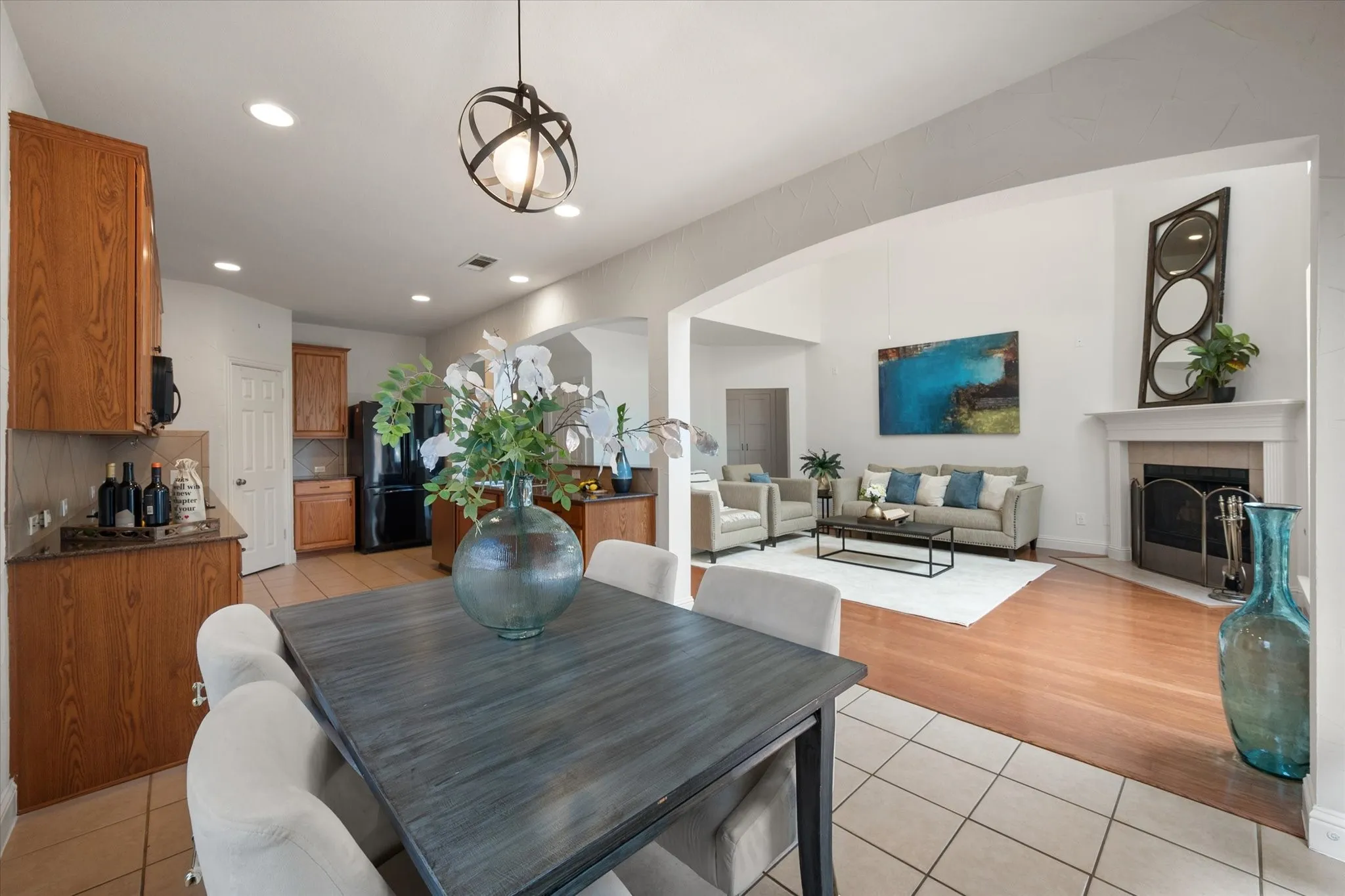 Dining area with an open concept design, featuring a contemporary spherical pendant light and tile flooring