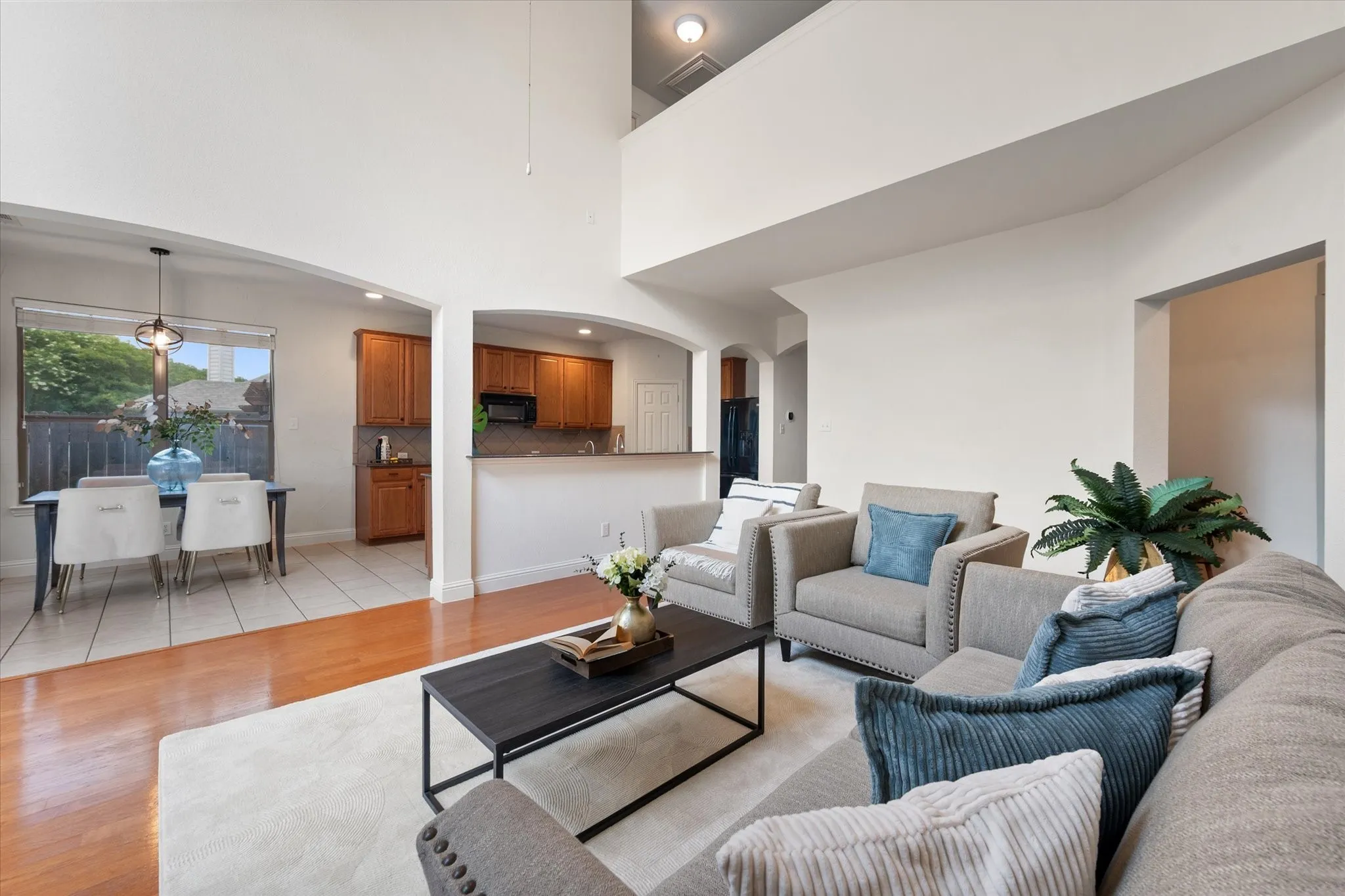 Living area featuring high ceilings, wood-finish flooring, and arched doorways