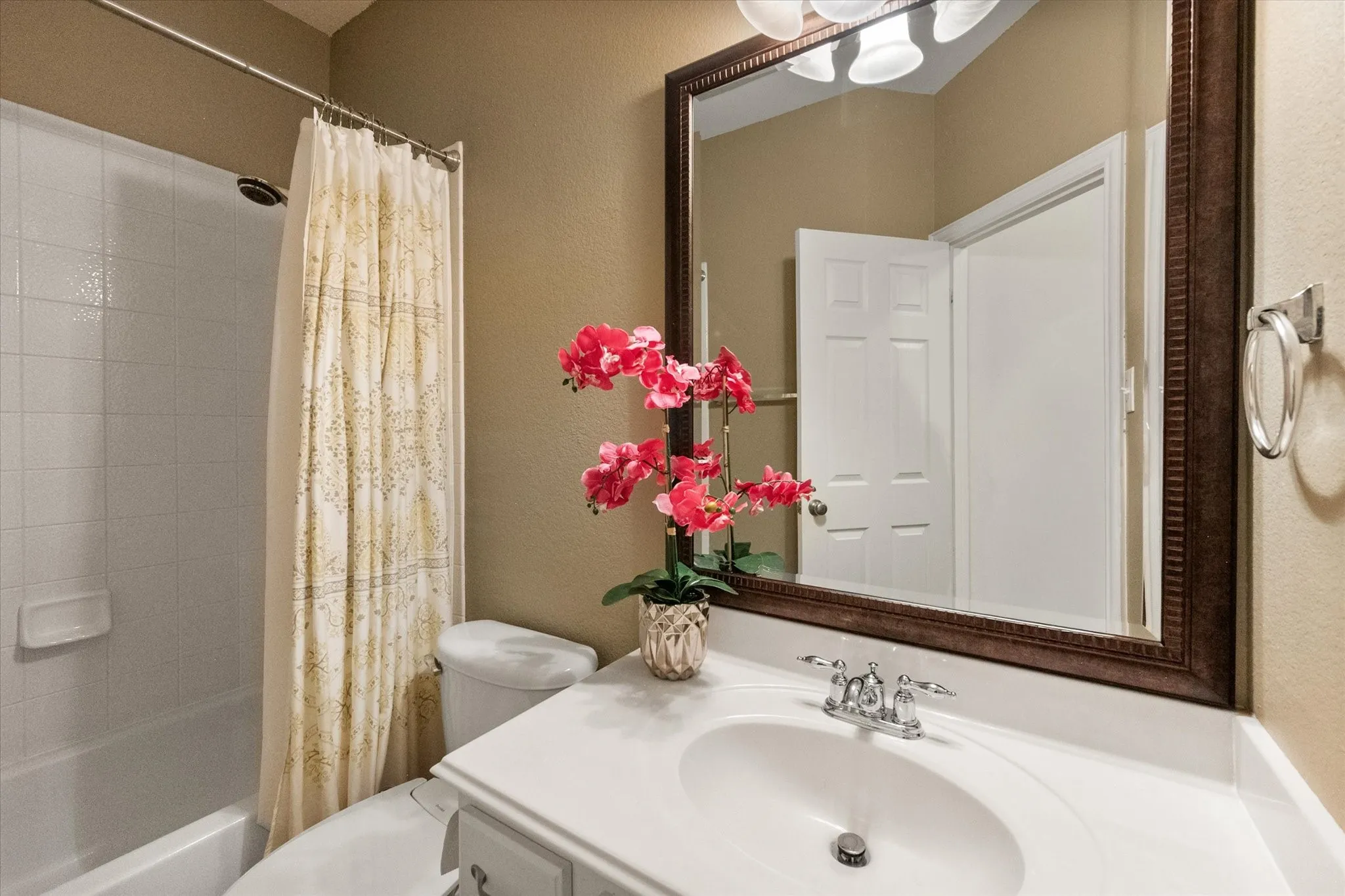 Downstairs Full Bathroom featuring a vanity with an integrated sink, a large framed mirror.
