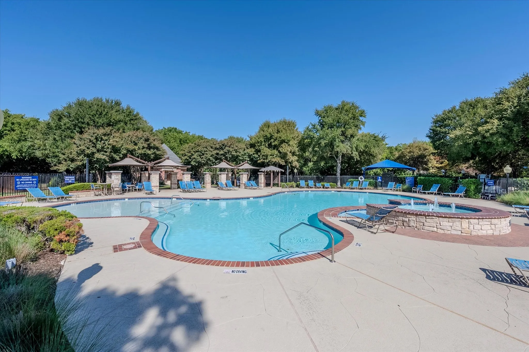 Resort-style swimming pool with an integrated spa featuring a water fountain