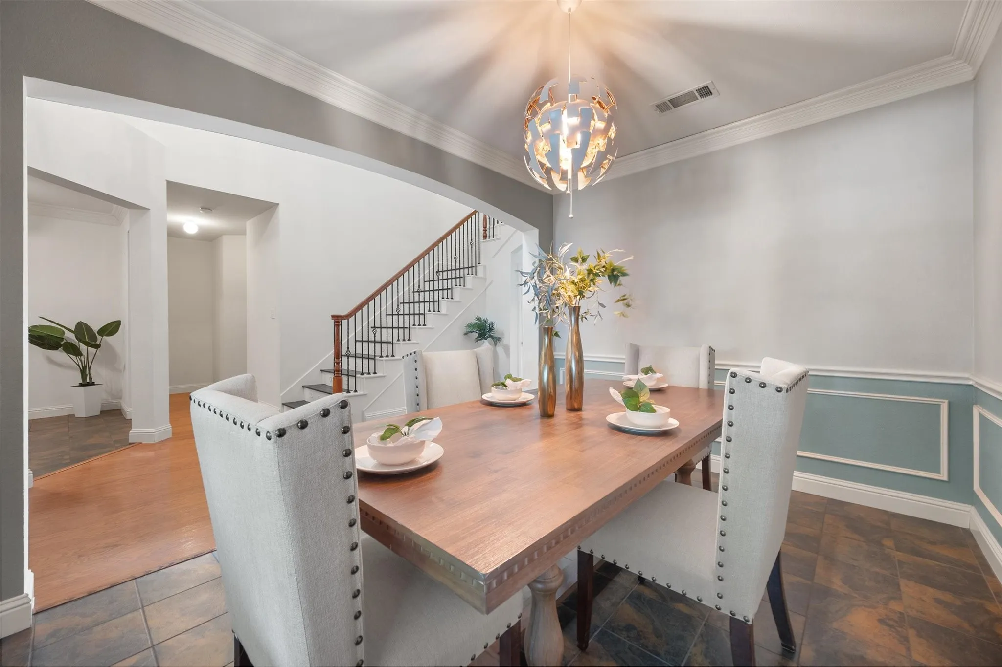 Formal Dining area featuring wainscoting with decorative trim, a contemporary spherical pendant light and wood floors.