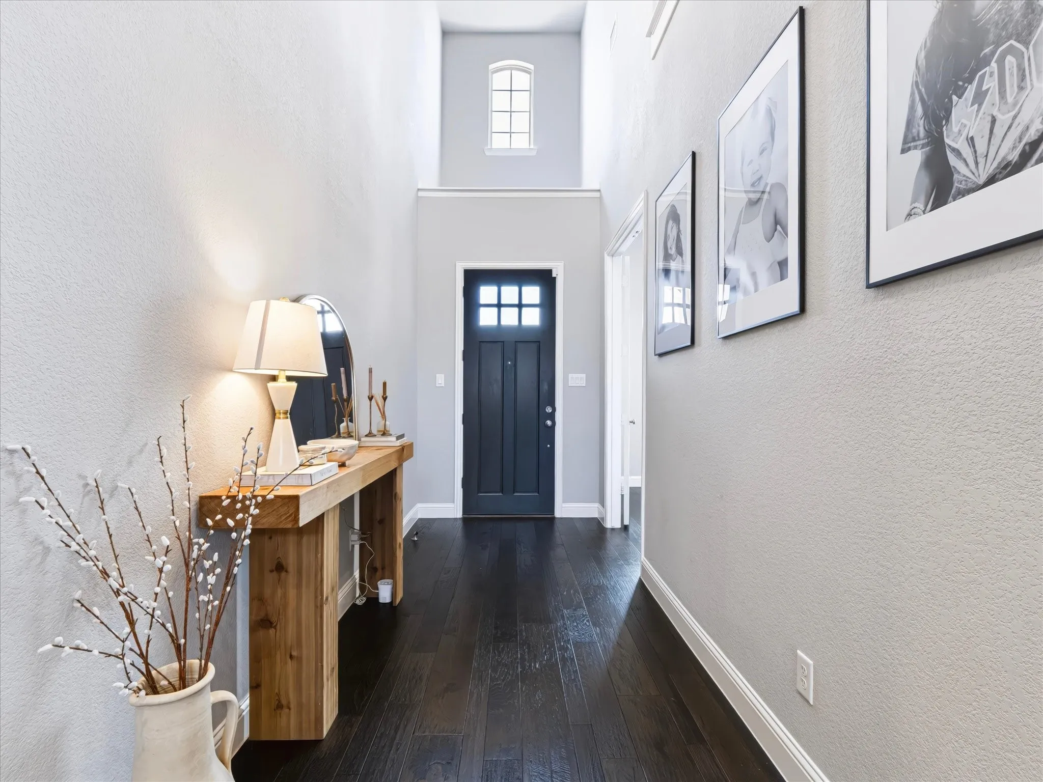 Dark wood-finish flooring leads to a dark paneled door with windowpanes